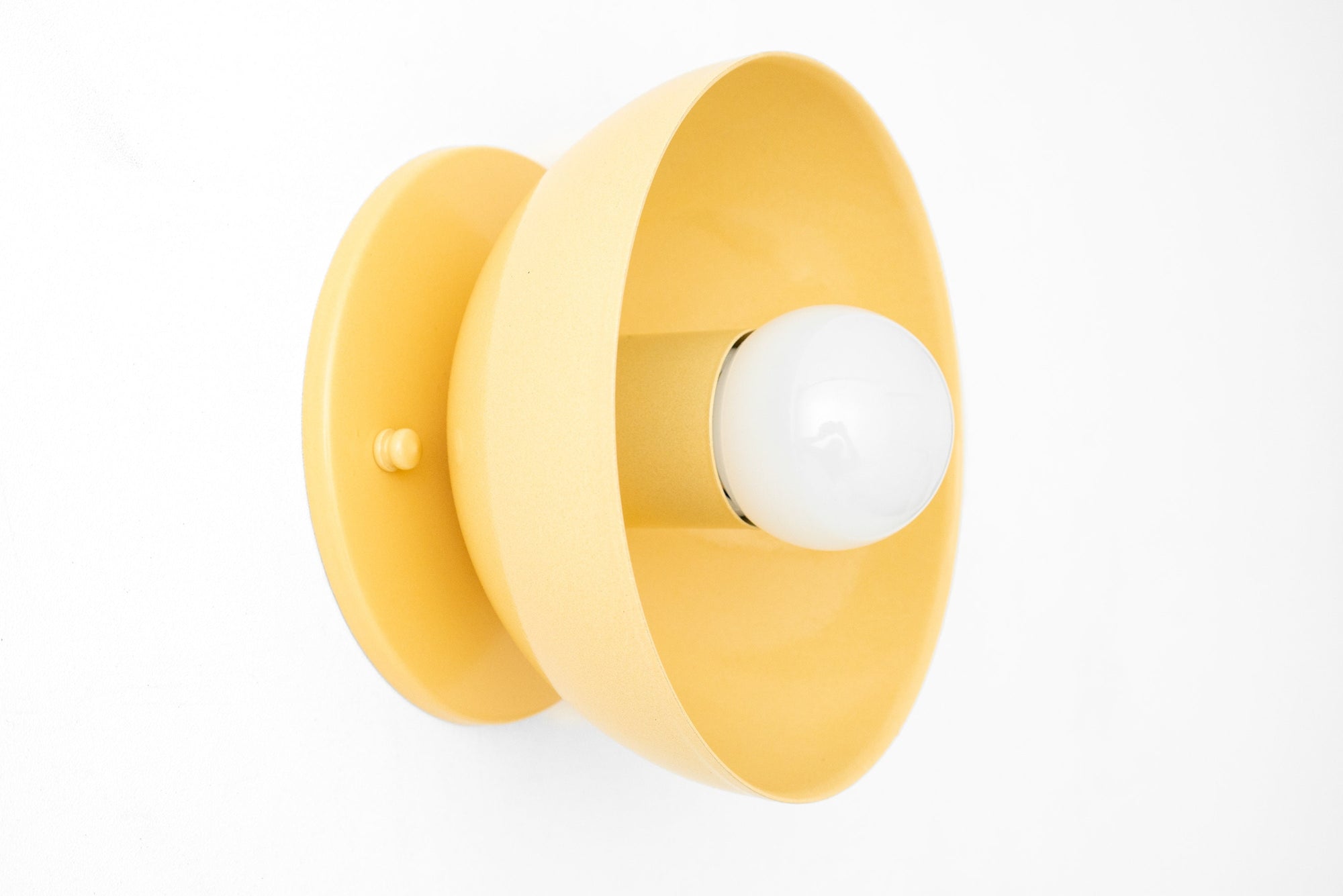 Yellow Scandinavian-style flush mount wall sconce with exposed white bulb and round base. - SCONCE MODEL NO. 4812