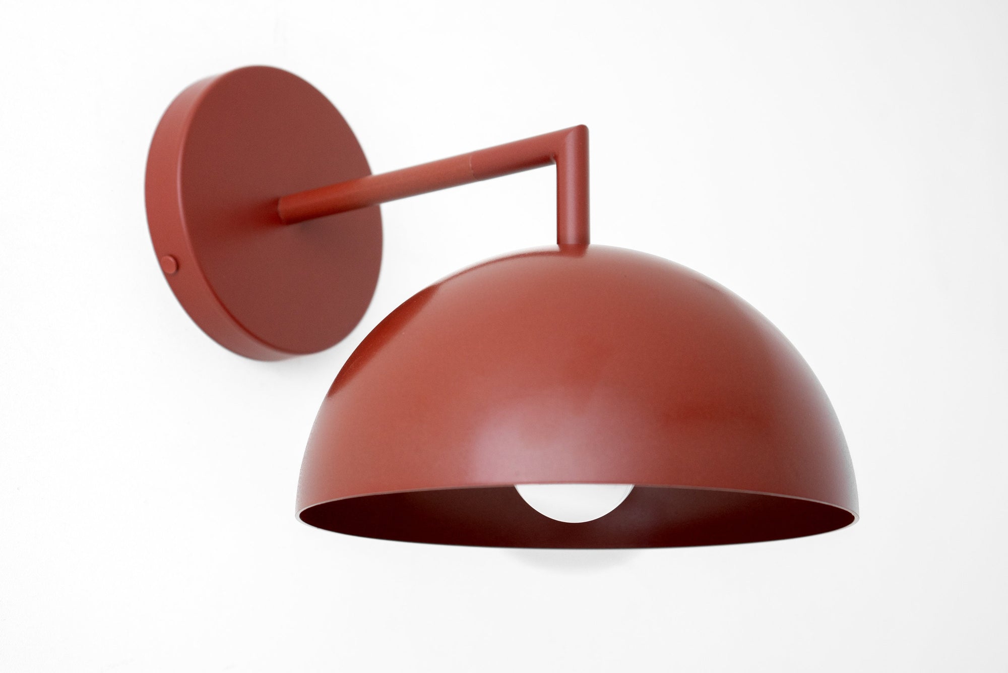 Scandinavian-style wall sconce with a matte brick red dome shade and minimalist arm design. - SCONCE MODEL NO. 6952