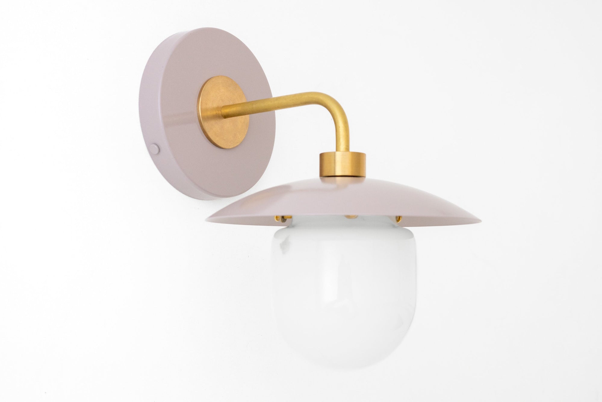 Mid-century modern wall sconce with raw brass arm and mauve circular backplate, frosted globe shade. - SCONCE MODEL NO. 7039