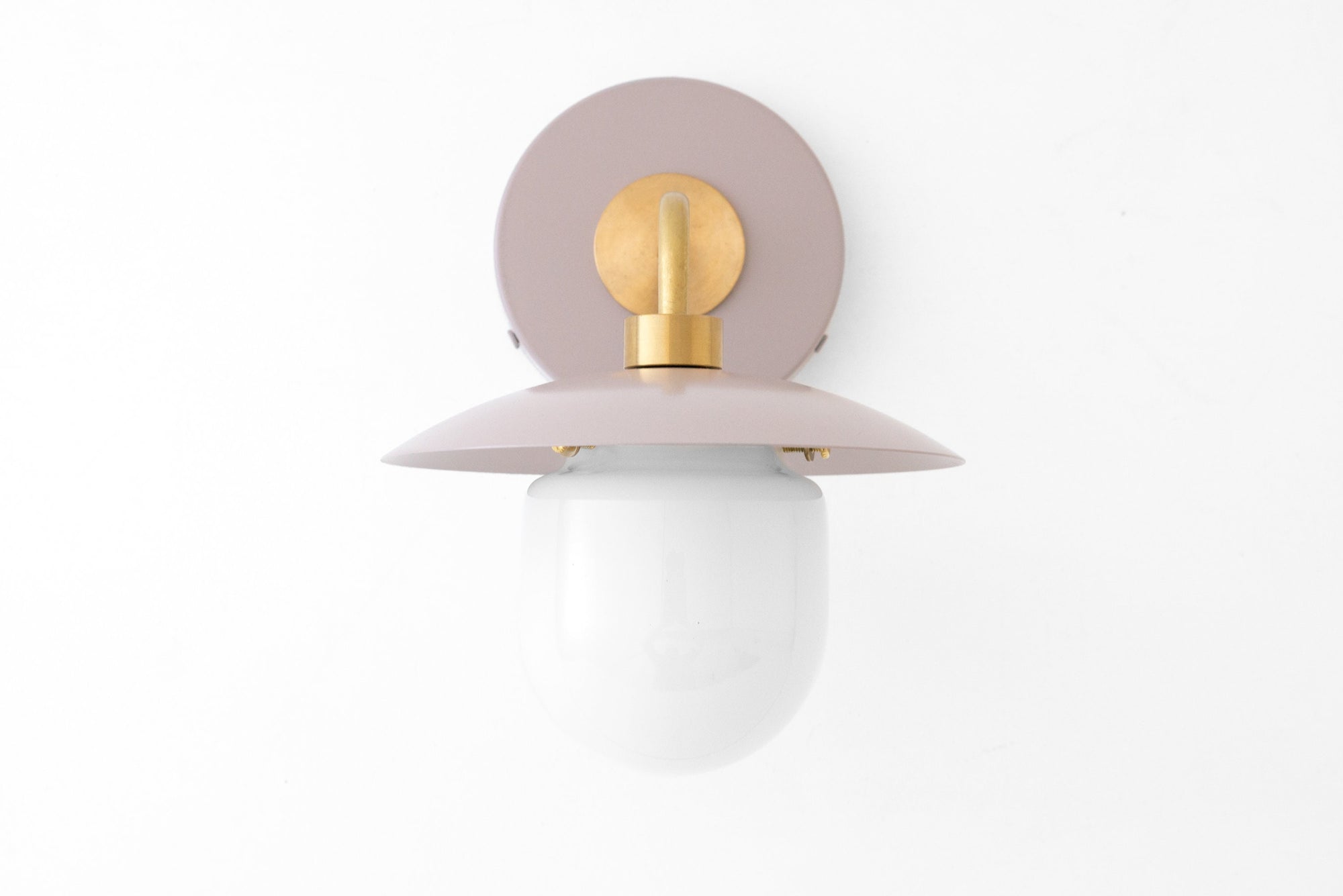 Mid-century modern wall sconce with raw brass fixture and mauve circular backplate, white globe shade. - SCONCE MODEL NO. 7039