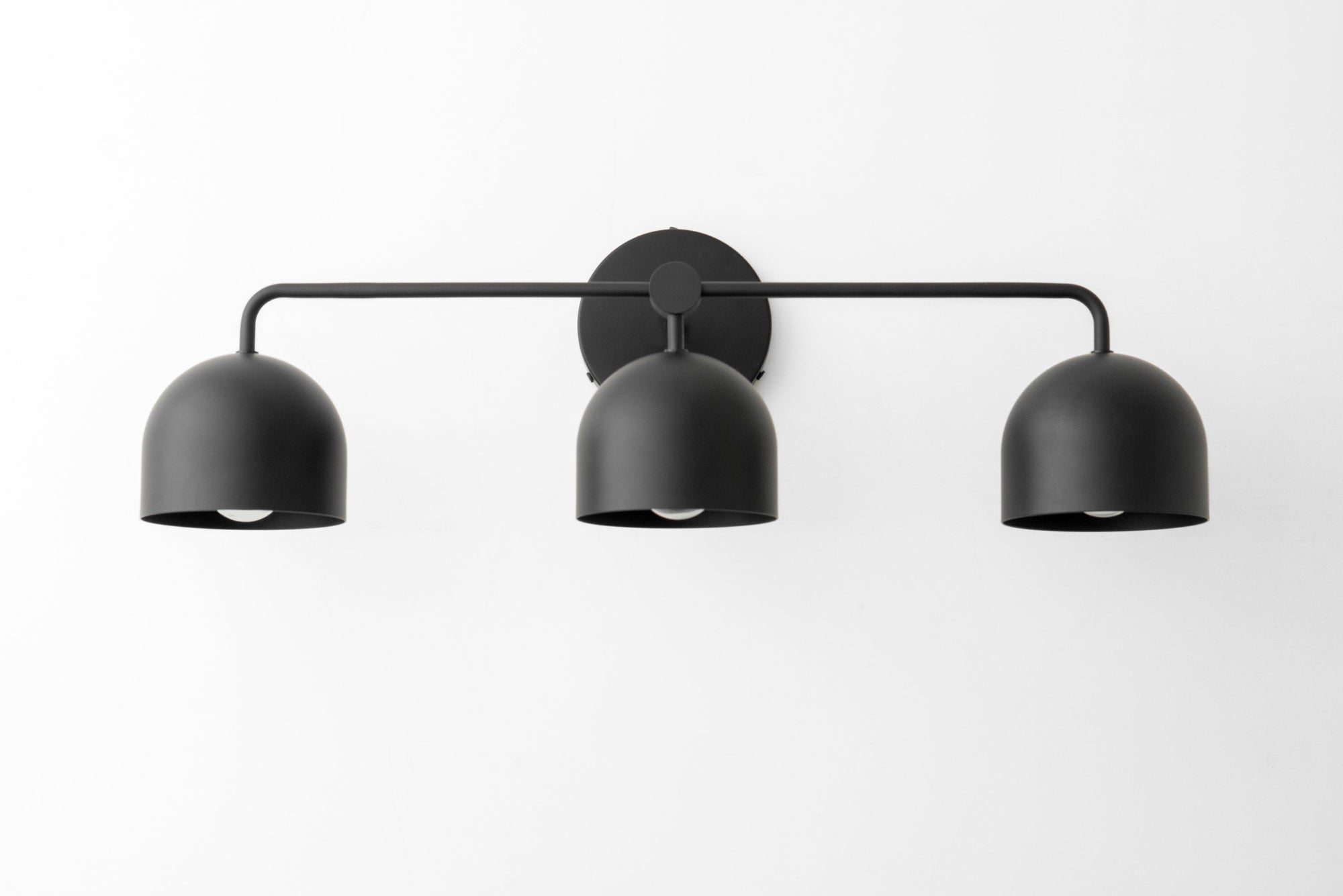 Matte black vanity light with three dome-shaped shades on a horizontal bar. - VANITY LIGHT MODEL NO. 7456
