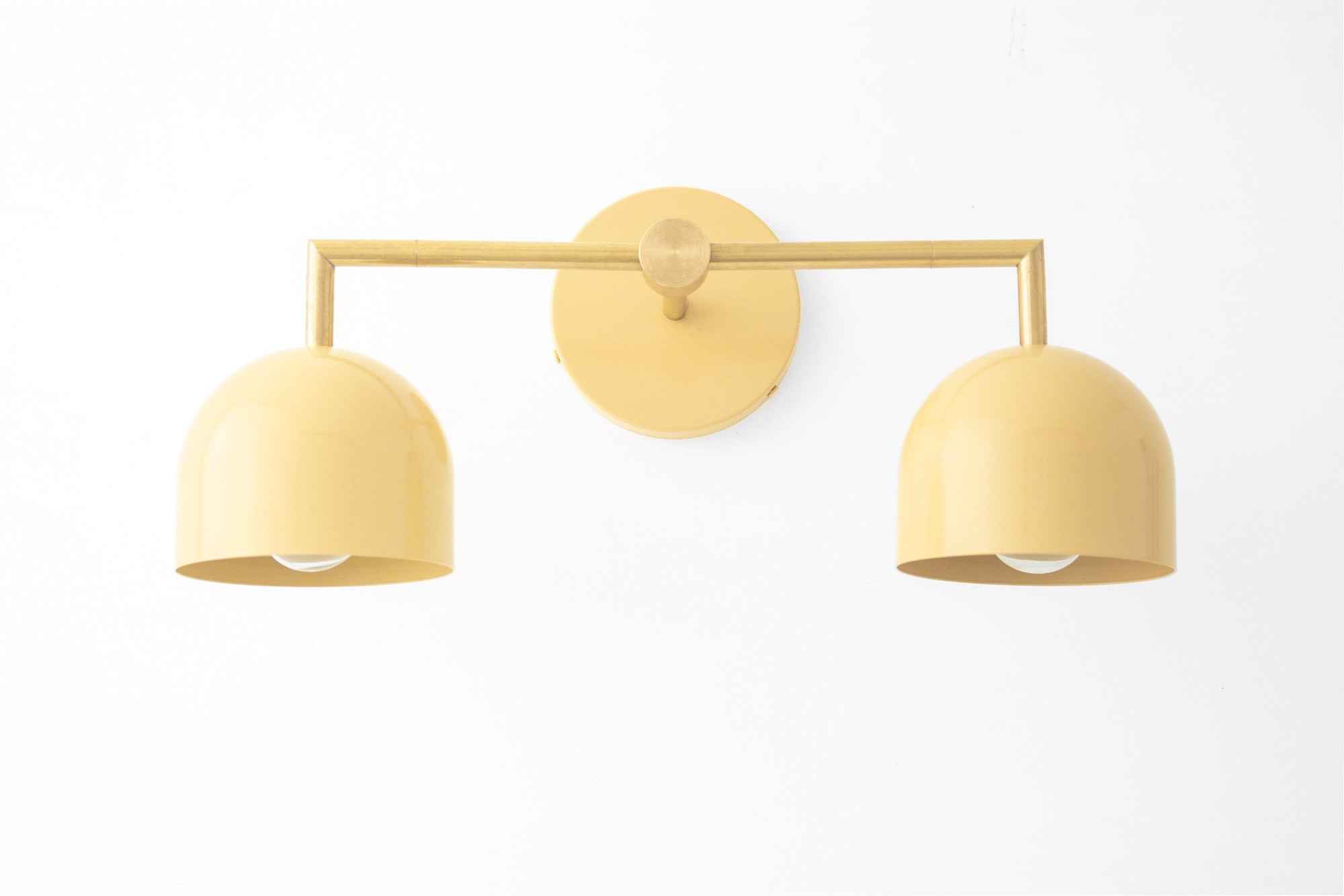 Raw brass two-bulb vanity light with smooth curved cream shades and round wall mount. - VANITY LIGHT MODEL NO. 8432