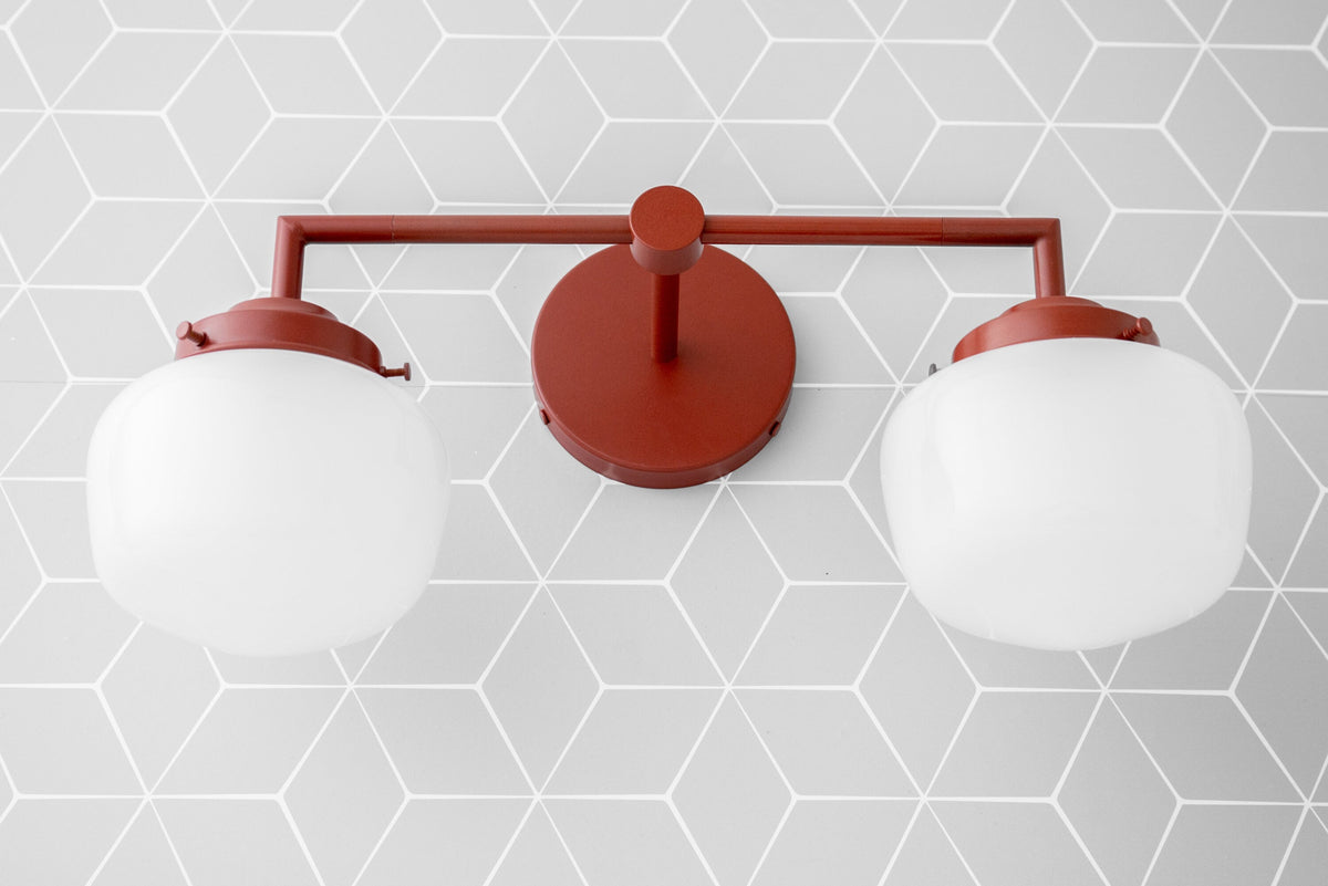 Art Deco two-bulb vanity light with brick red metal frame and frosted white globe shades. - VANITY LIGHT MODEL NO. 0276