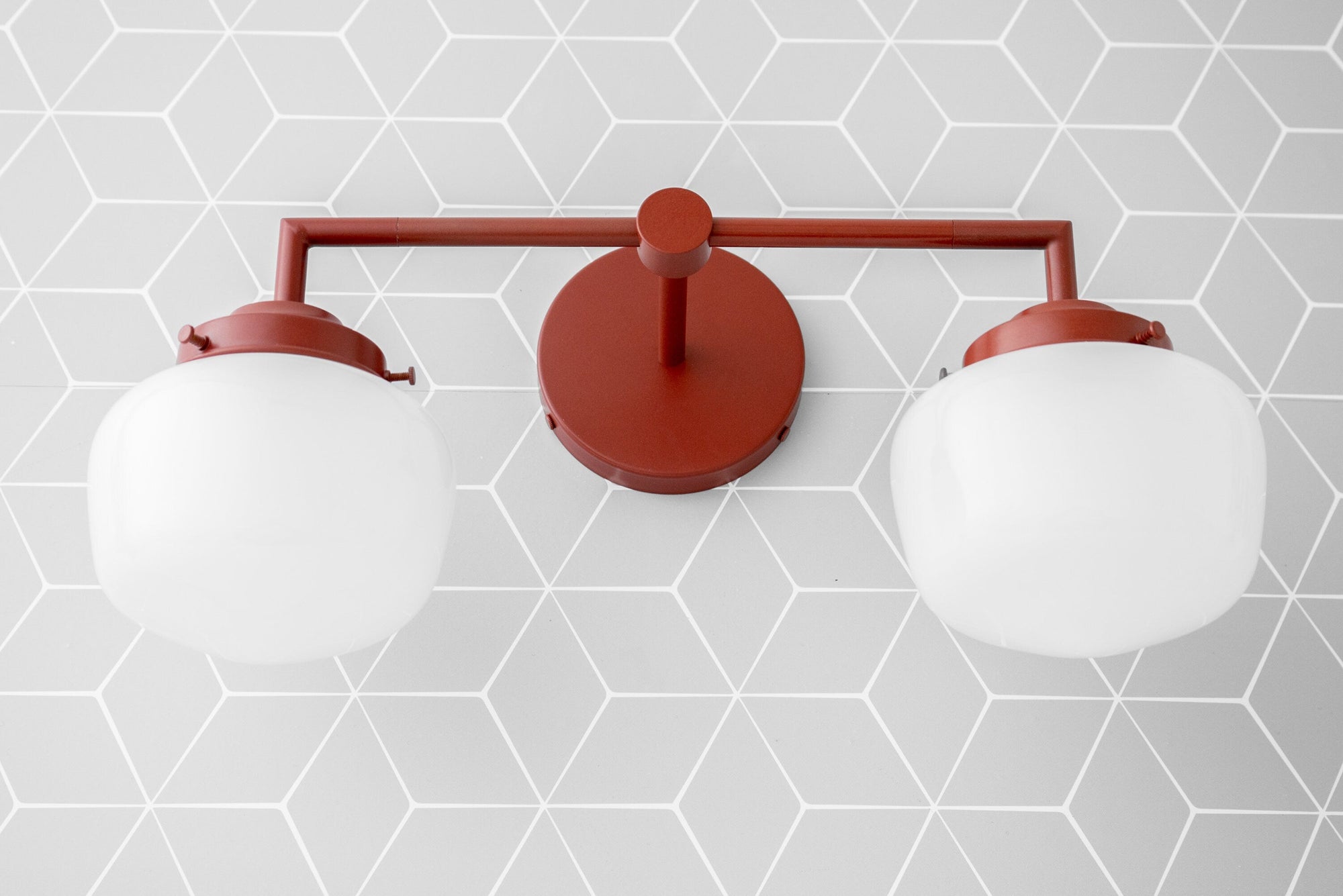 Art Deco two-bulb vanity light with brick red metal frame and frosted white globe shades. - VANITY LIGHT MODEL NO. 0276