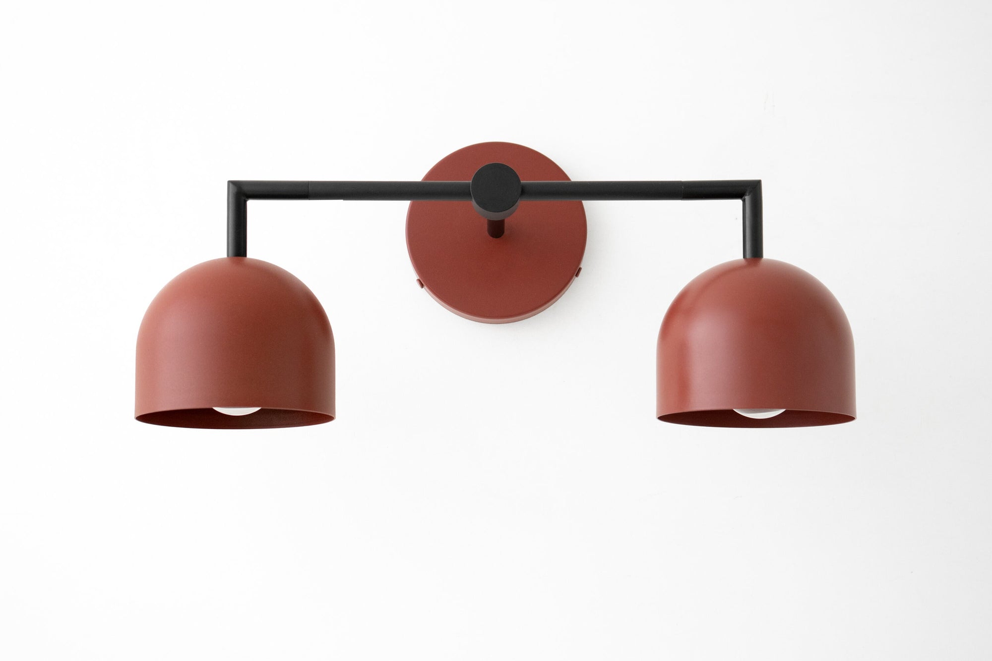 Black metal vanity light with two brick red dome shades and a round wall mount. - VANITY LIGHT MODEL NO. 8432