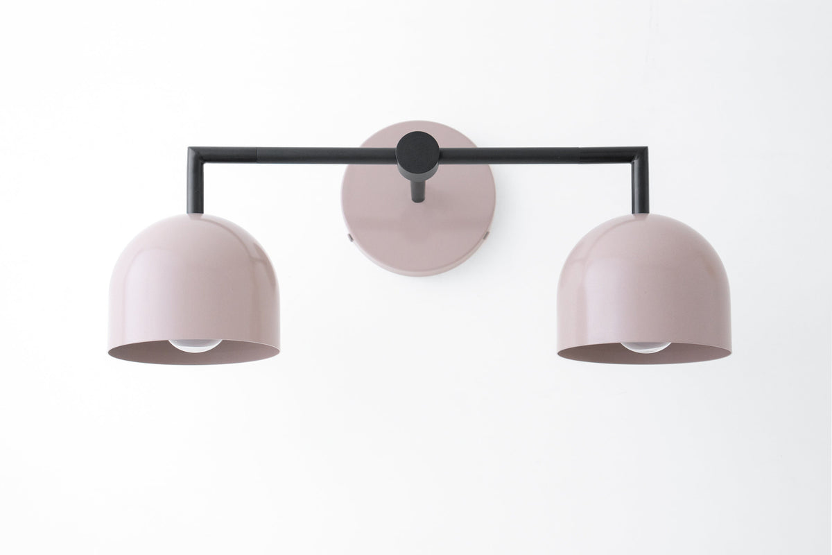 Black metal 2-bulb vanity light with mauve dome shades and round wall mount. - VANITY LIGHT MODEL NO. 8432