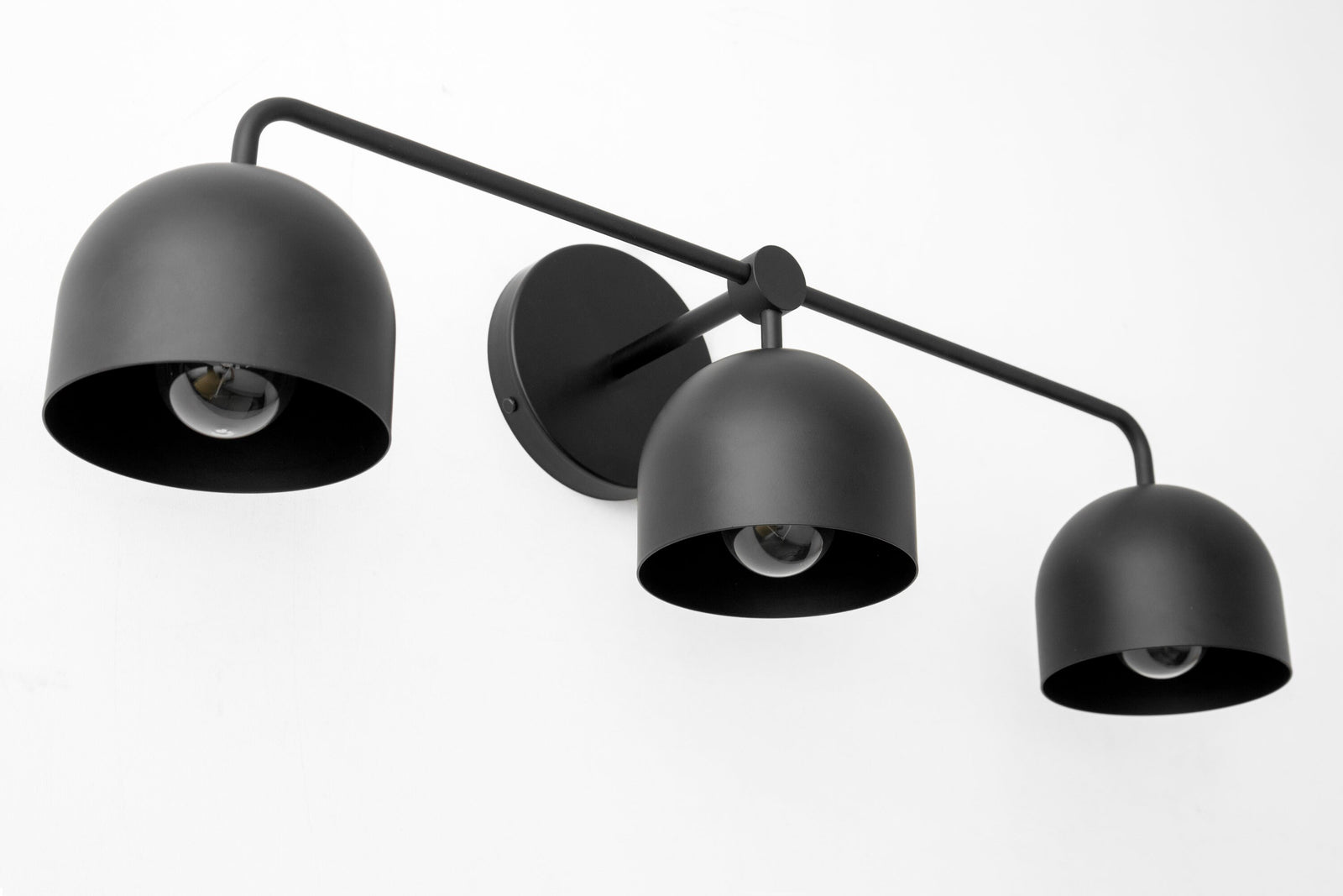 Three-bulb matte black vanity light with dome-shaped shades and horizontal bar mount. - VANITY LIGHT MODEL NO. 7456