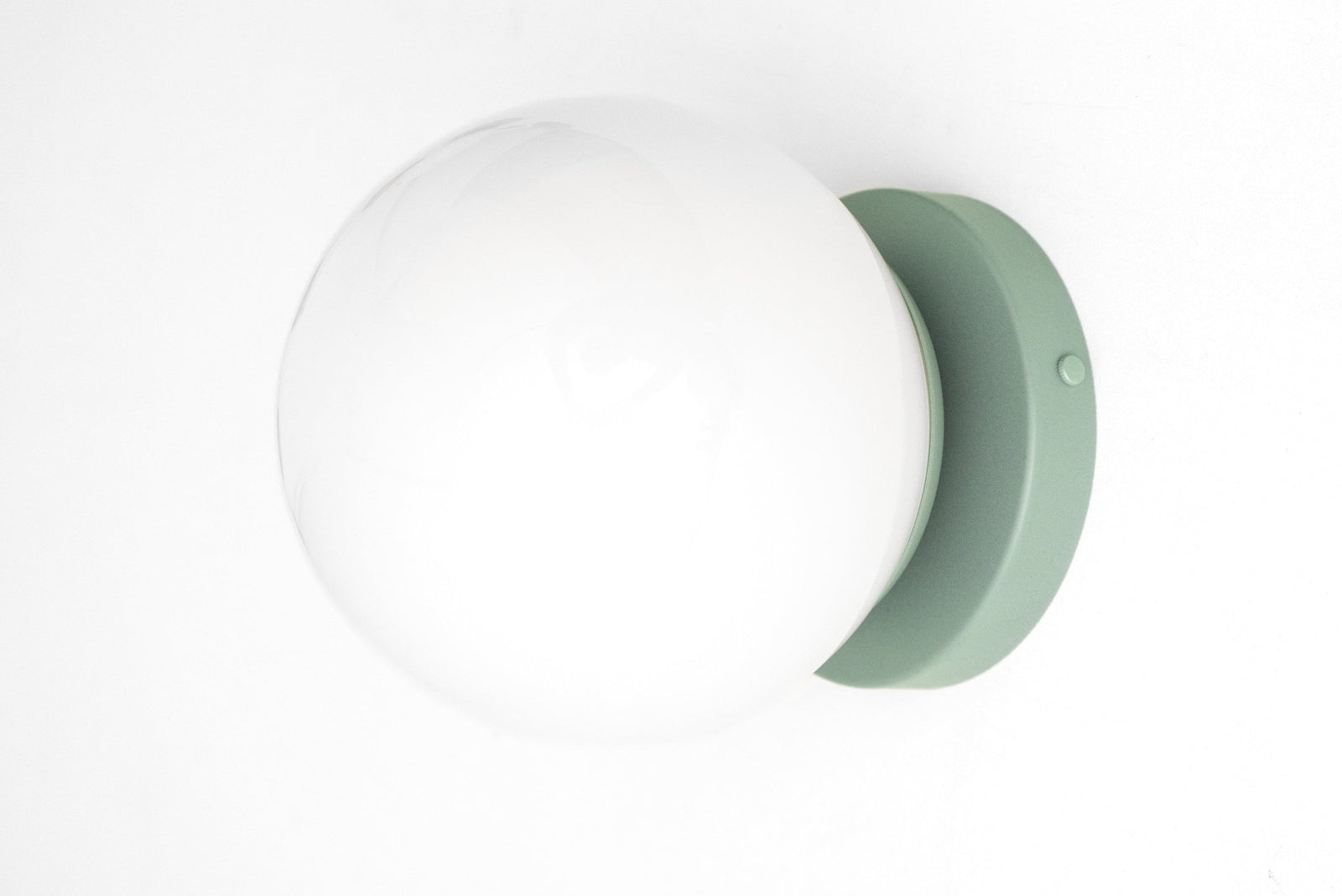 Mid-century modern wall sconce with a white globe and matte pastel green flush mount. - SCONCE MODEL NO. 3825