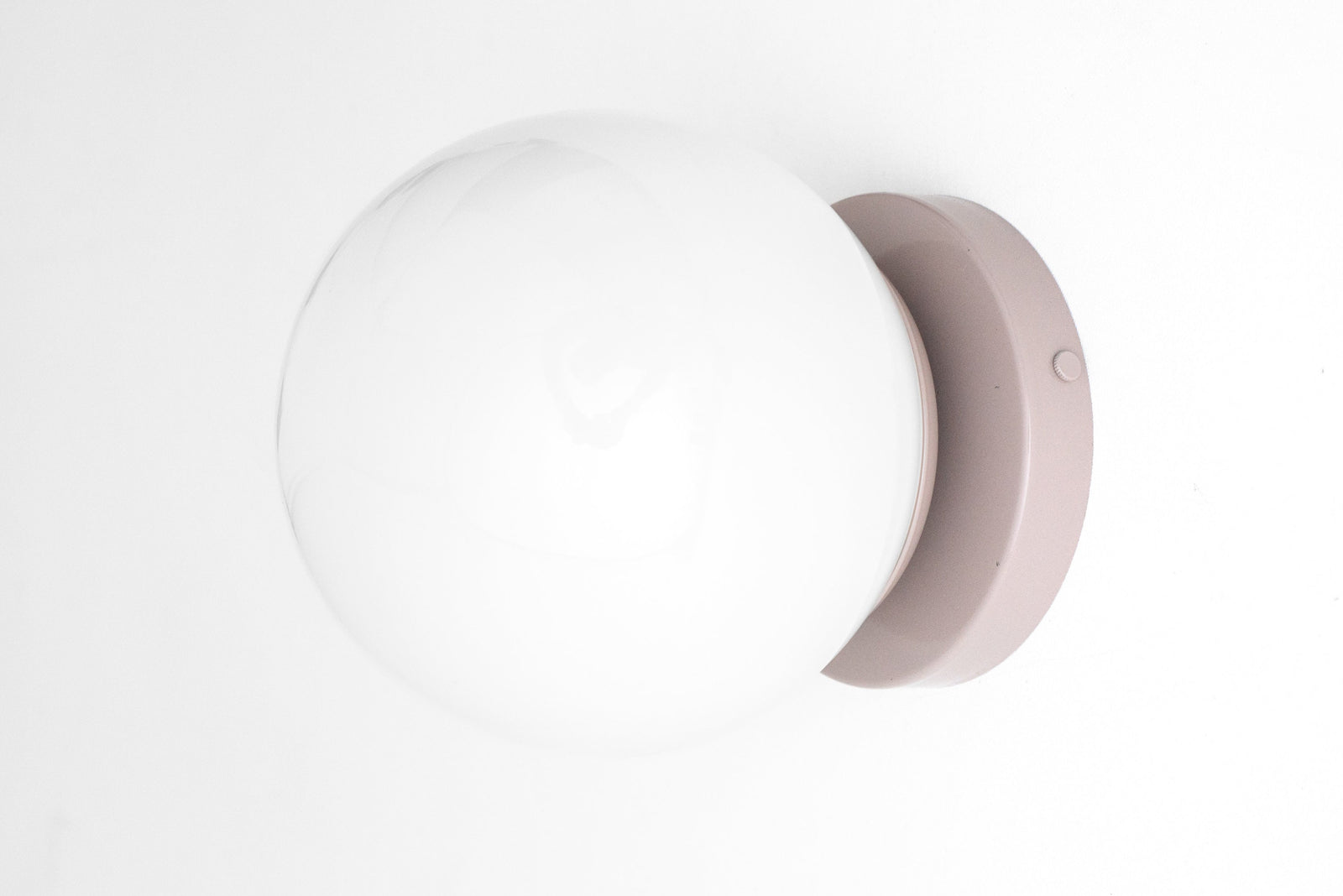 Mid-century modern wall sconce with a matte mauve flush mount and large opaque white glass globe shade. - SCONCE MODEL NO. 3825