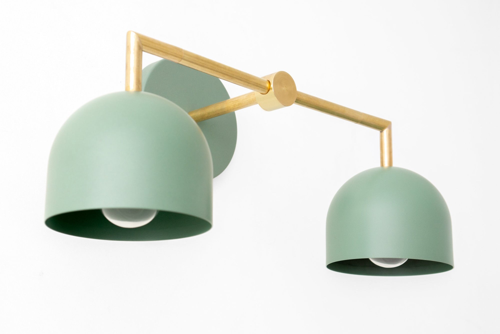 Raw brass vanity light with two matte green dome shades and adjustable arms. - VANITY LIGHT MODEL NO. 8432