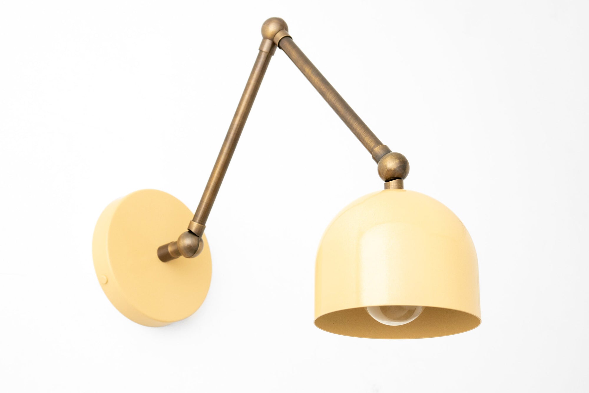 Adjustable antique brass wall sconce with cream dome shade and exposed bulb design. - SCONCE MODEL NO. 5998