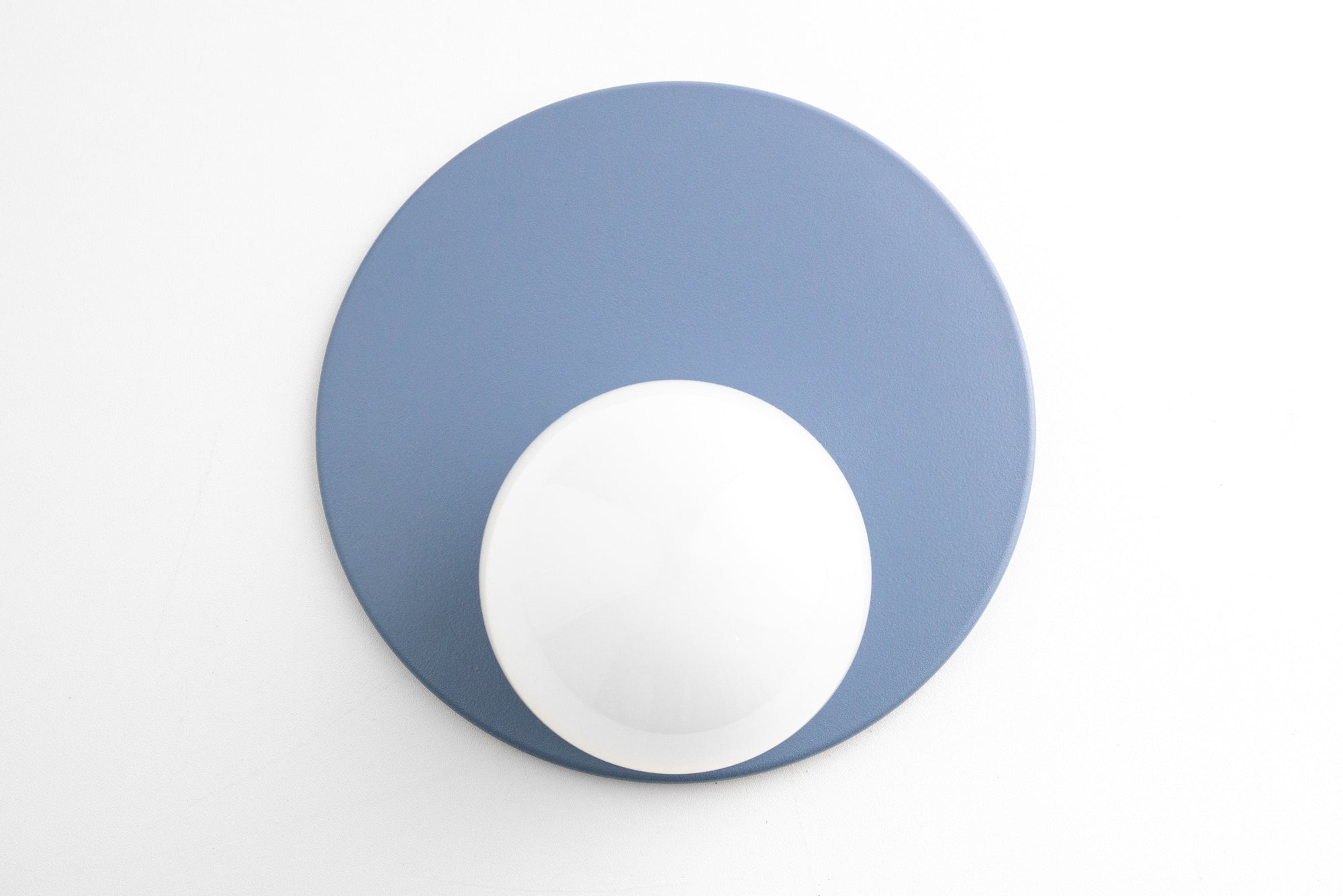 Mid-century modern Scandinavian wall sconce with periwinkle blue circular backplate and white globe light. - SCONCE MODEL NO. 6703