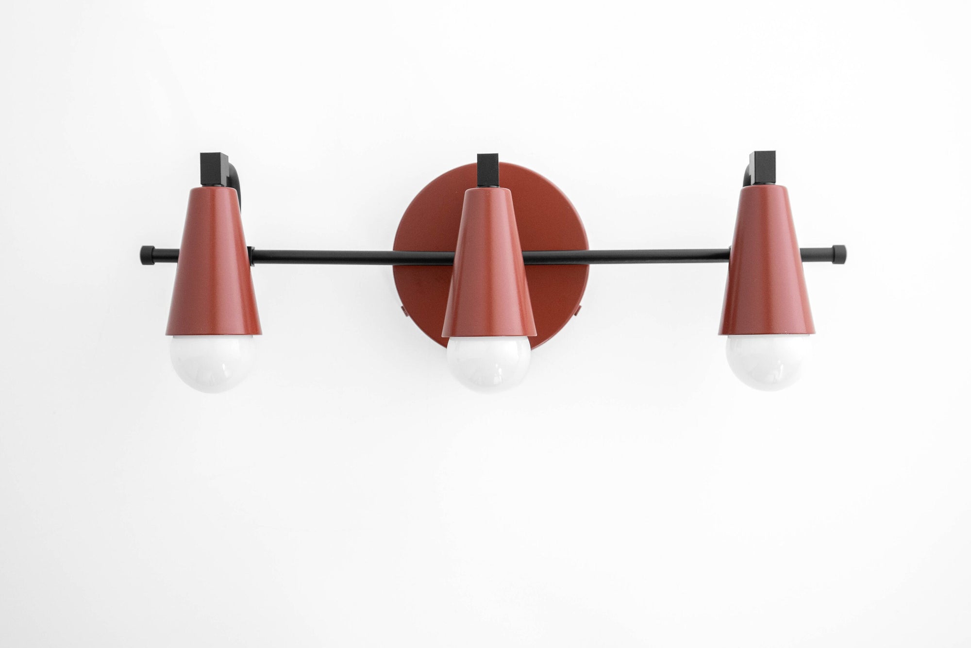 Mid-century modern 3-bulb vanity light with brick red conical shades and matte black metal base. - VANITY LIGHT MODEL NO. 8084