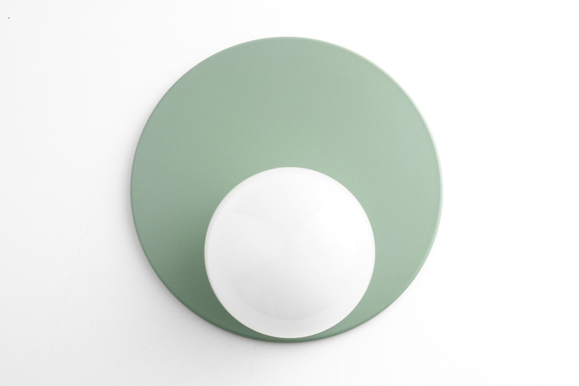 Mid-century modern sconce with matte green circular backplate and white globe light. - SCONCE MODEL NO. 6703