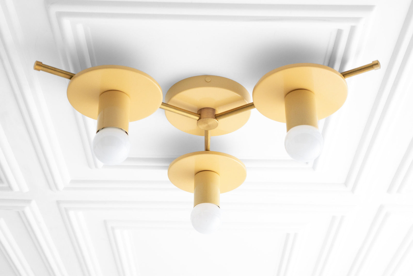 Mid-century modern flush mount chandelier with three matte gold fixtures and white bare bulbs on white ceiling paneling. - CHANDELIER MODEL NO. 9526