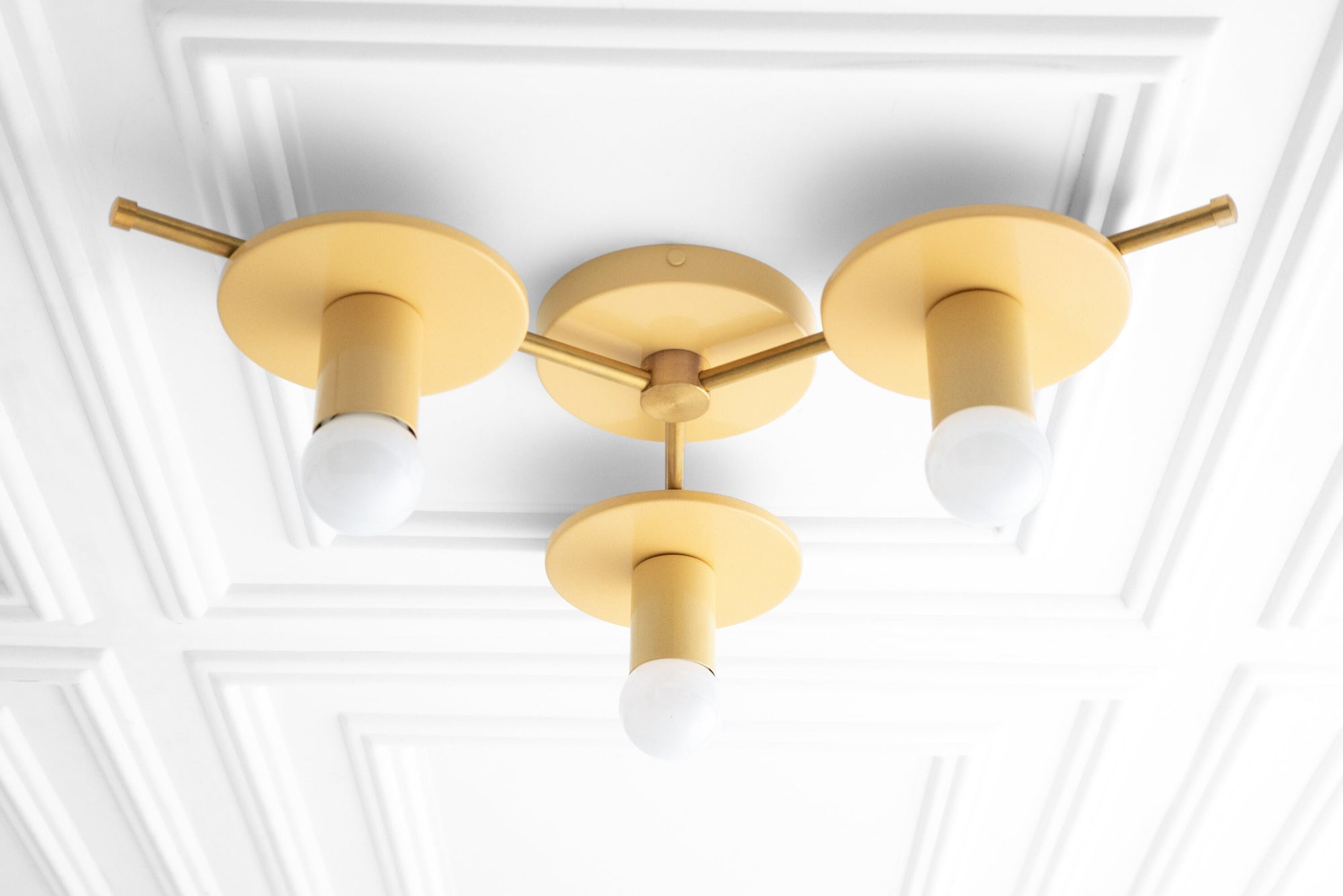 Mid-century modern flush mount chandelier with three matte gold fixtures and white bare bulbs on white ceiling paneling. - CHANDELIER MODEL NO. 9526