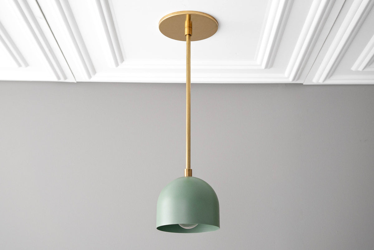 Scandinavian pendant light with raw brass fixture and matte green dome shade hanging from ceiling. - PENDANT MODEL NO. 8906