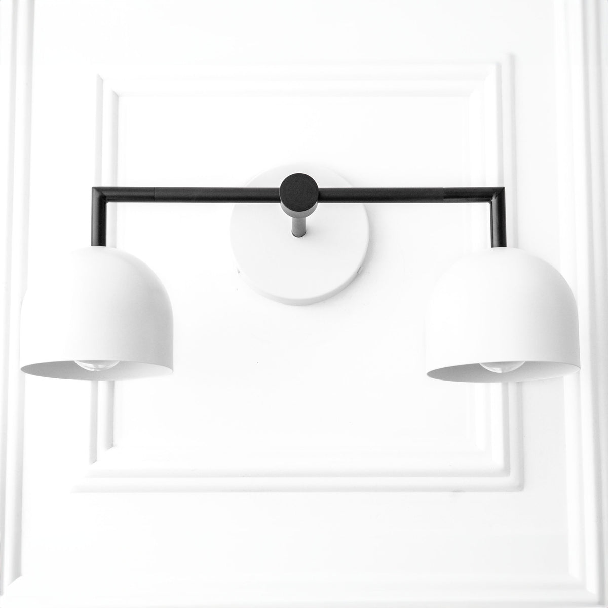 Black metal 2-bulb vanity light with smooth white dome shades and round wall mount. - VANITY LIGHT MODEL NO. 8432