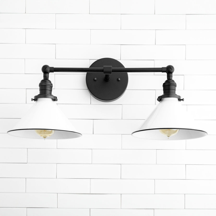 Industrial-style black vanity light with two white metal shades and exposed bulbs mounted on a horizontal bar. - VANITY LIGHT MODEL NO. 2362
