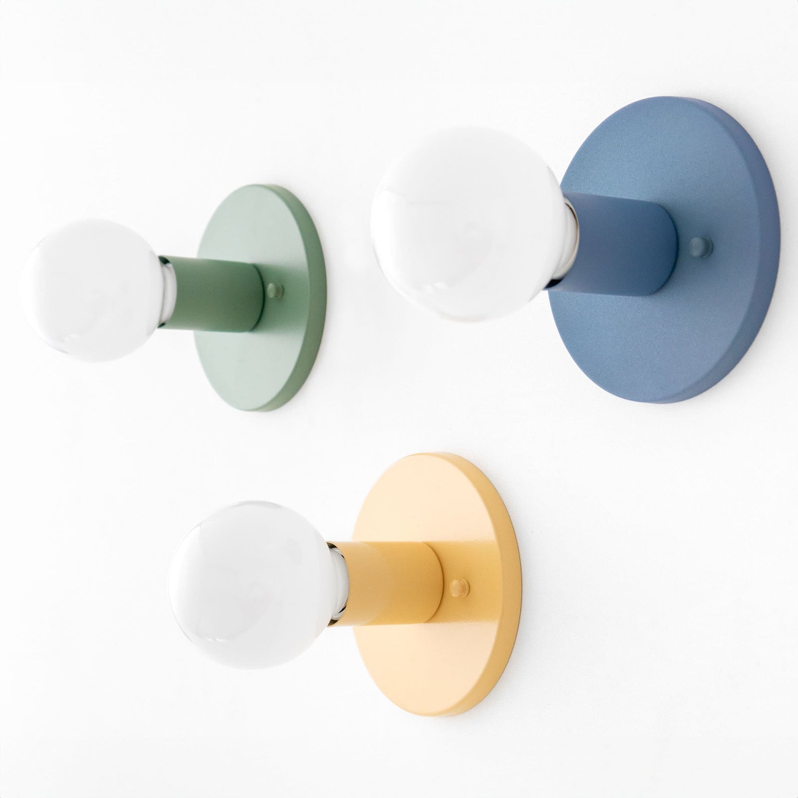 Three flush mount sconces in green, yellow, and coal blue with exposed round bulbs, mid-century modern style. - SCONCE MODEL NO. 4460