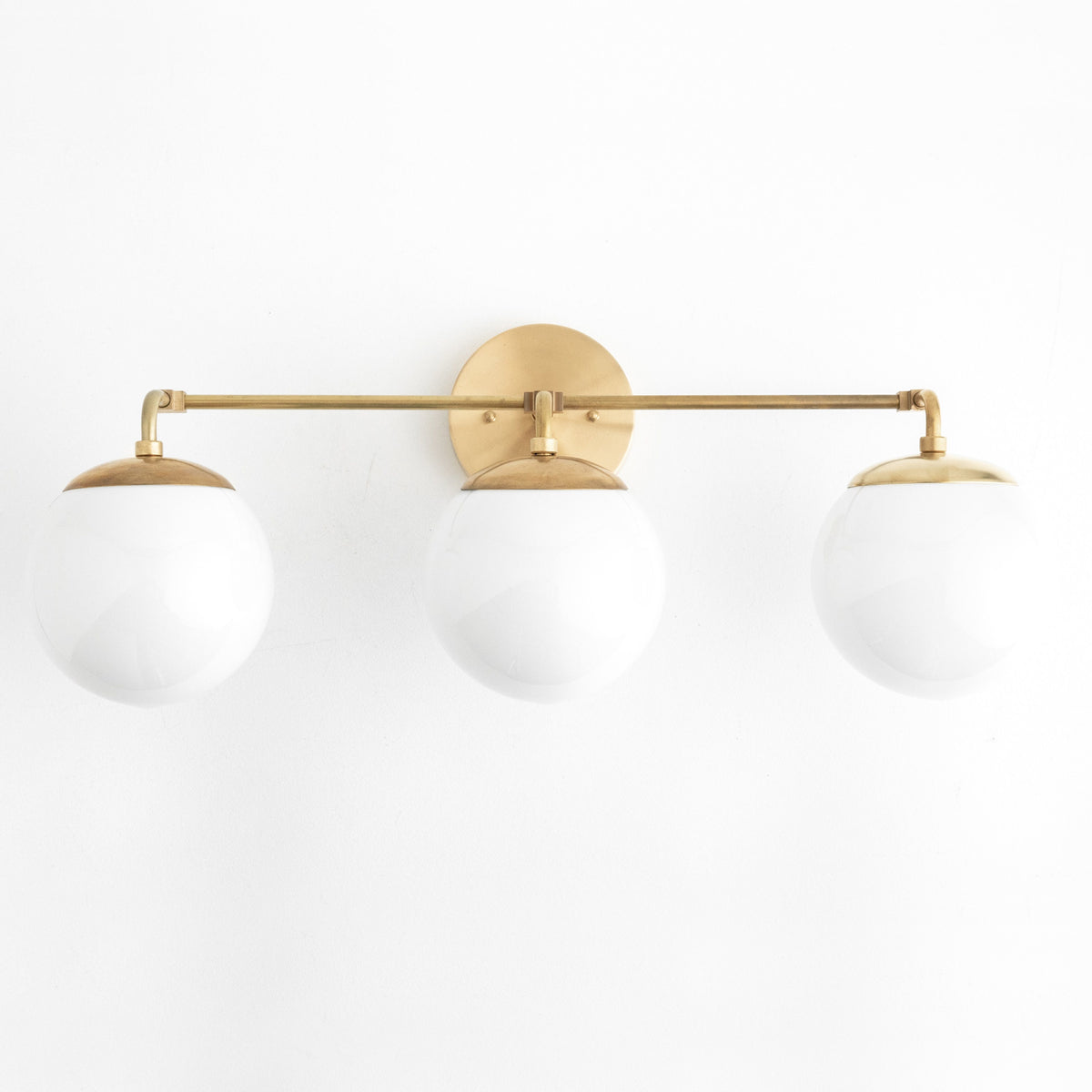 Mid-century modern vanity light with three white glass globes and raw brass finish. - VANITY LIGHT MODEL NO. 9319