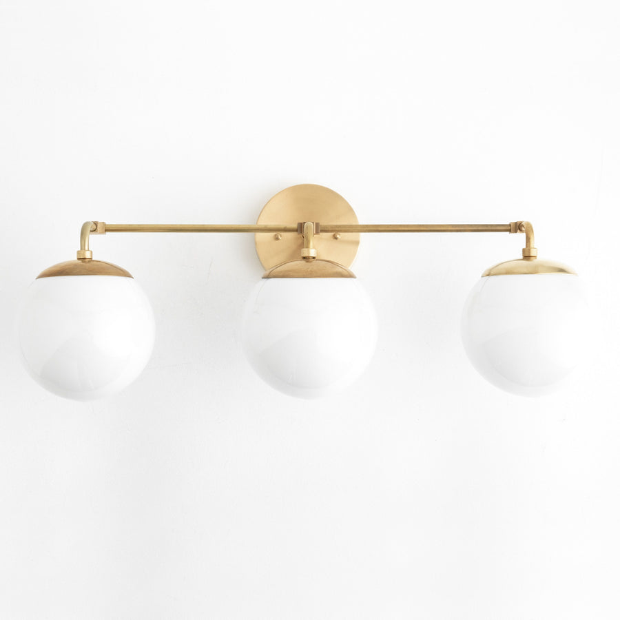 Mid-century modern vanity light with three white glass globes and raw brass finish. - VANITY LIGHT MODEL NO. 9319