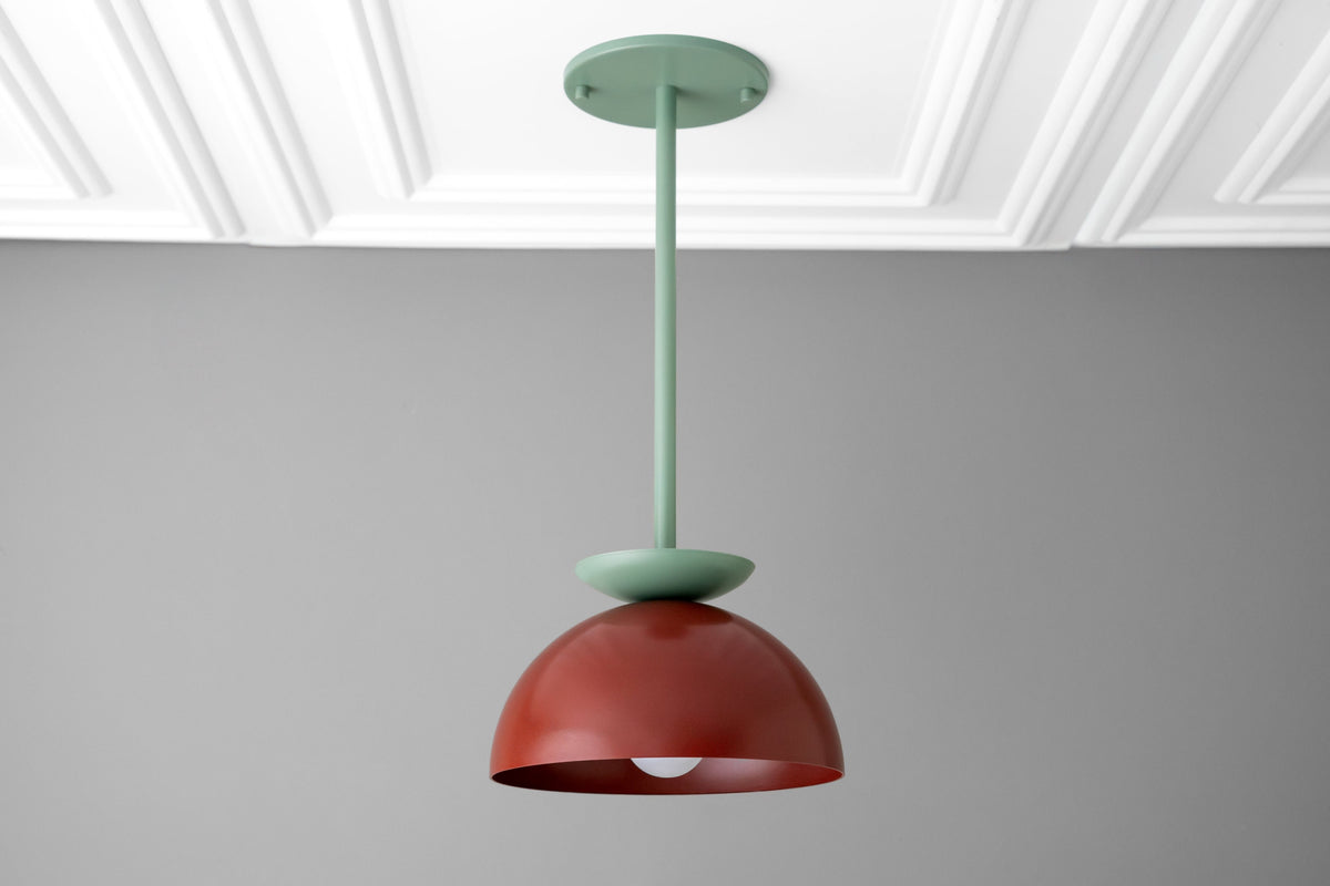 Scandinavian dome pendant light with green stem and brick red dome shade hanging from ceiling. - PENDANT MODEL NO. 4975
