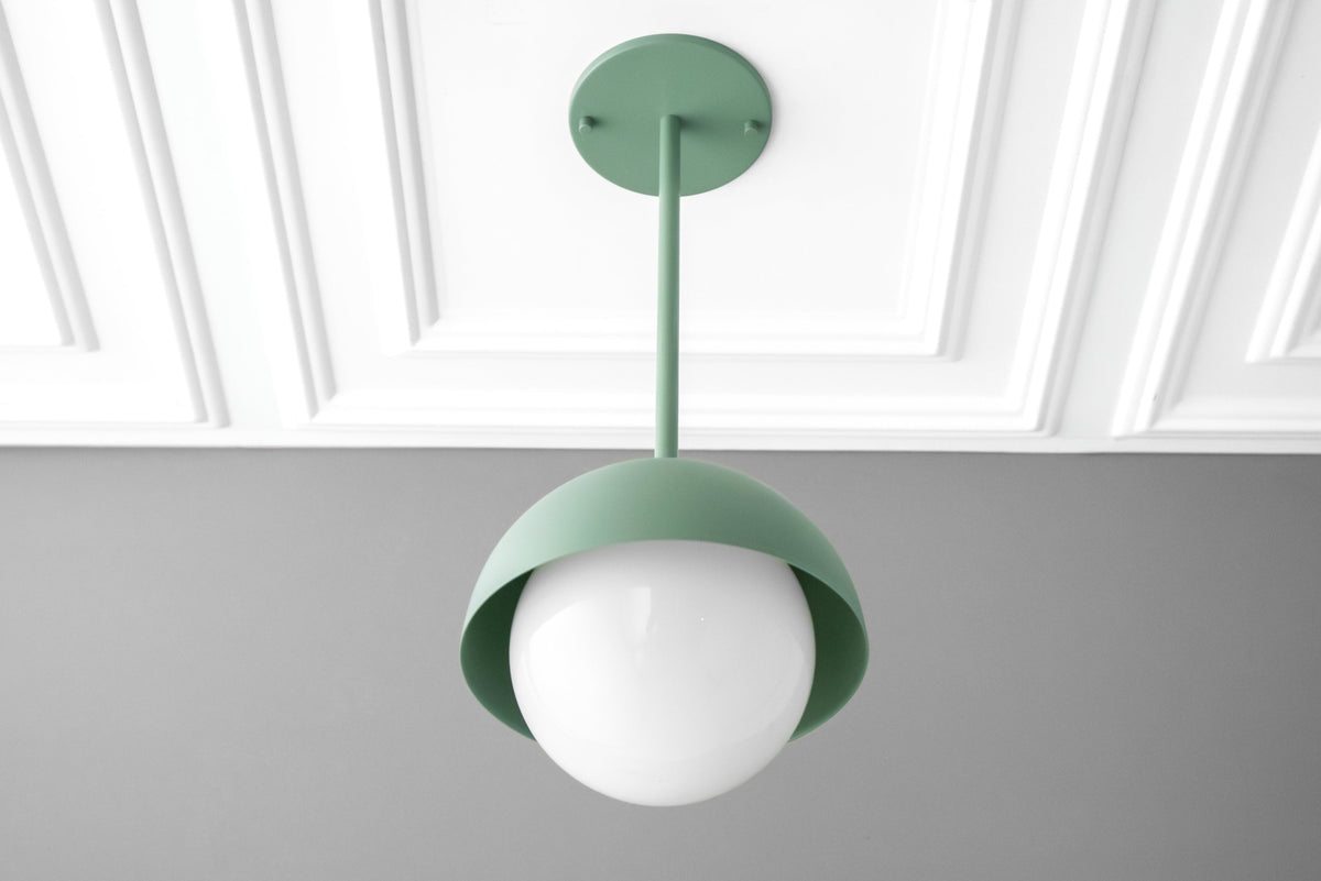 Matte green dome pendant light with white frosted globe suspended from matching ceiling mount. - PENDANT MODEL NO. 6357