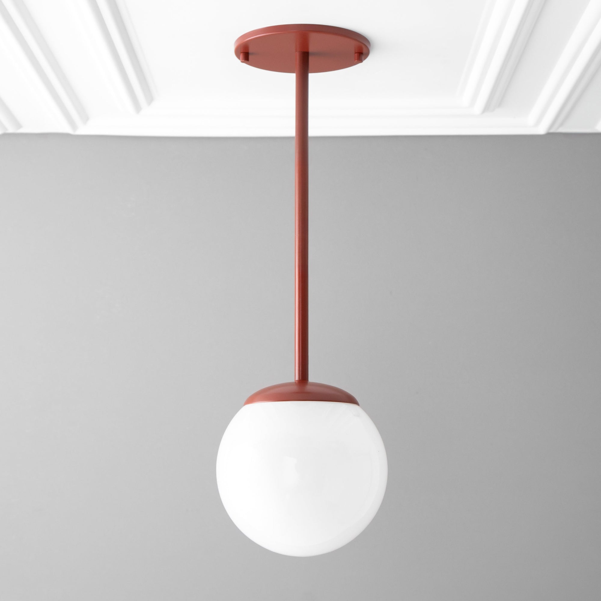 Brick red mid-century modern pendant light with white globe shade hanging from ceiling mount. - PENDANT MODEL NO. 7559