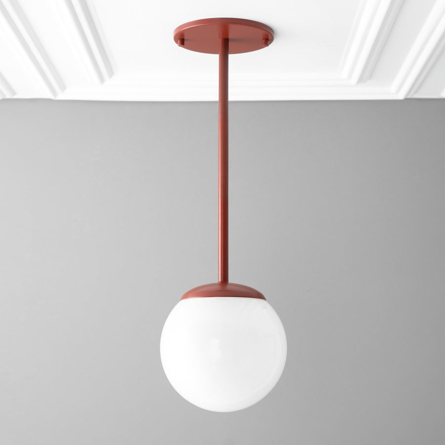 Brick red mid-century modern pendant light with white globe shade hanging from ceiling mount. - PENDANT MODEL NO. 7559
