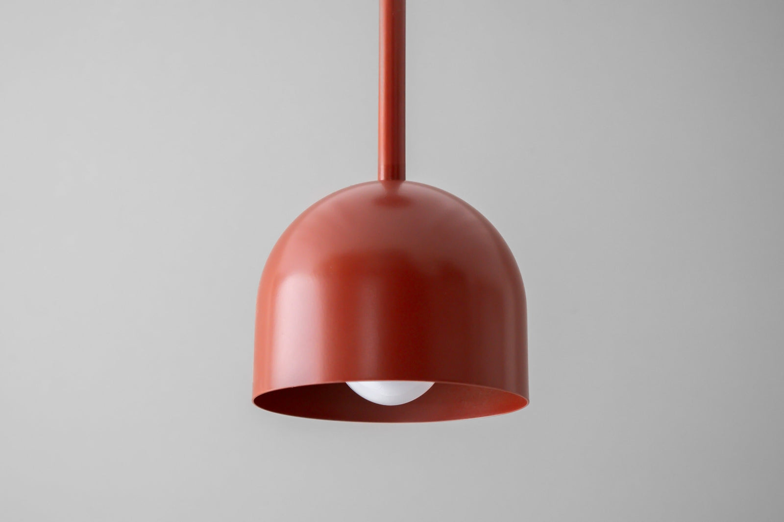Brick red Scandinavian deep ball pendant light with smooth matte finish and exposed bulb below shade. - PENDANT MODEL NO. 4745
