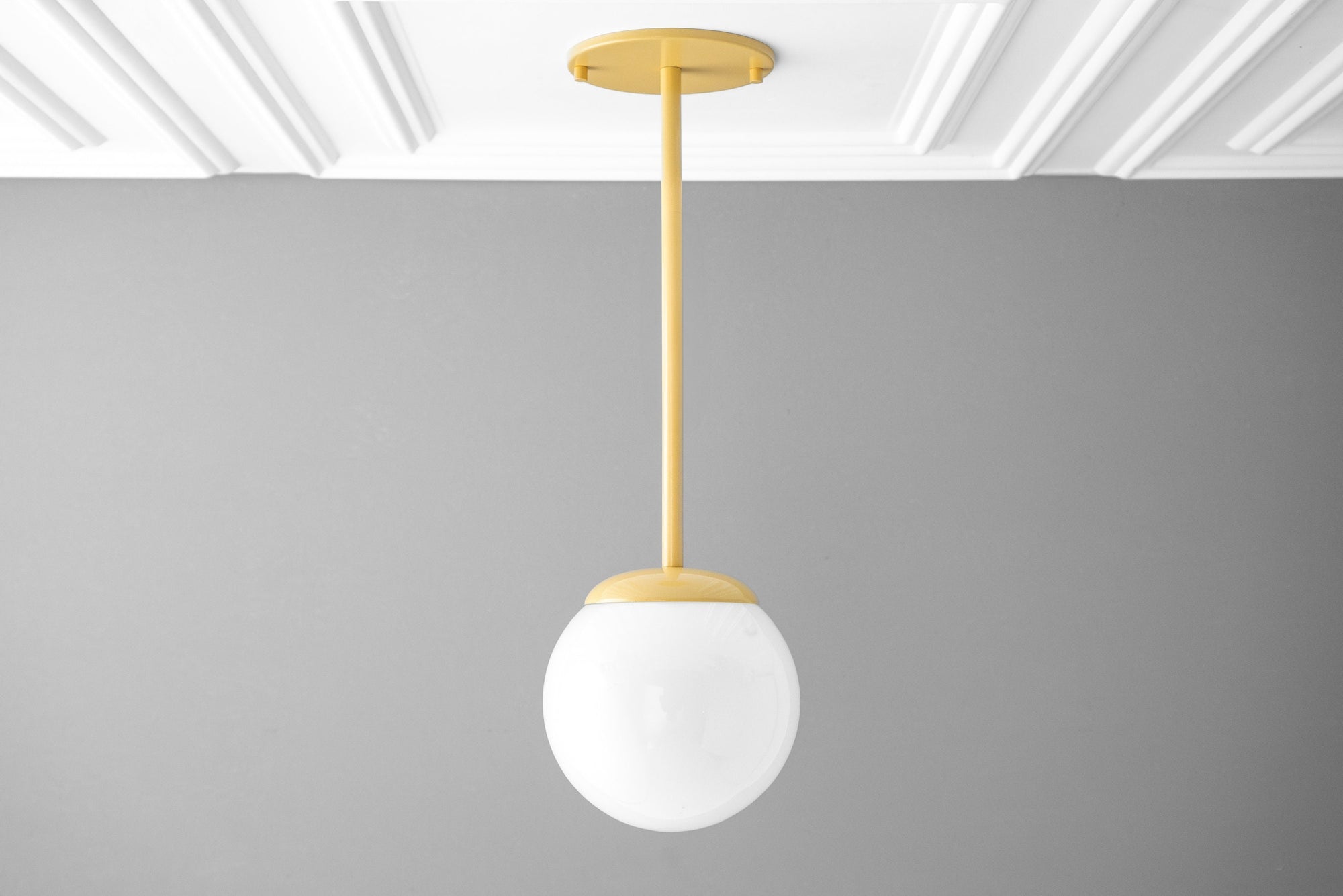 Mid-century modern pendant light with matte yellow ceiling mount and frosted white globe shade. - PENDANT MODEL NO. 7559