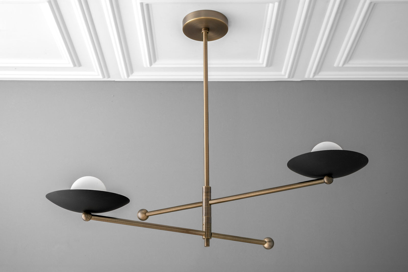Minimalist industrial chandelier with antique brass finish and two black globe shades. - CHANDELIER MODEL NO. 2933