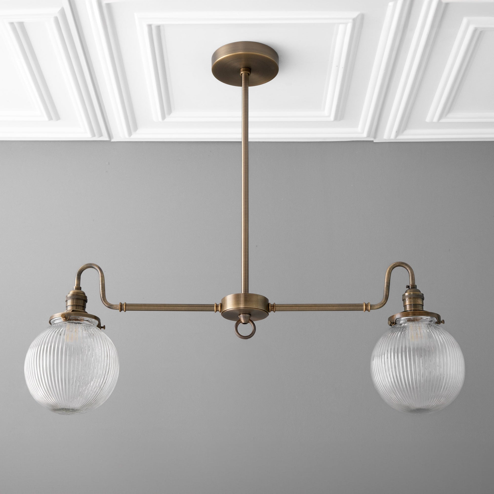 Antique brass linear chandelier with two ribbed glass globe shades and adjustable rod suspension. - CHANDELIER MODEL NO. 7424