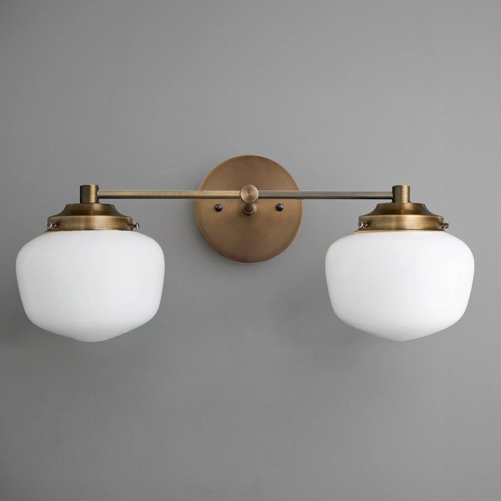Mid-century modern two-bulb vanity light with round frosted glass globes and antique brass fixtures. - VANITY LIGHT MODEL NO. 5799