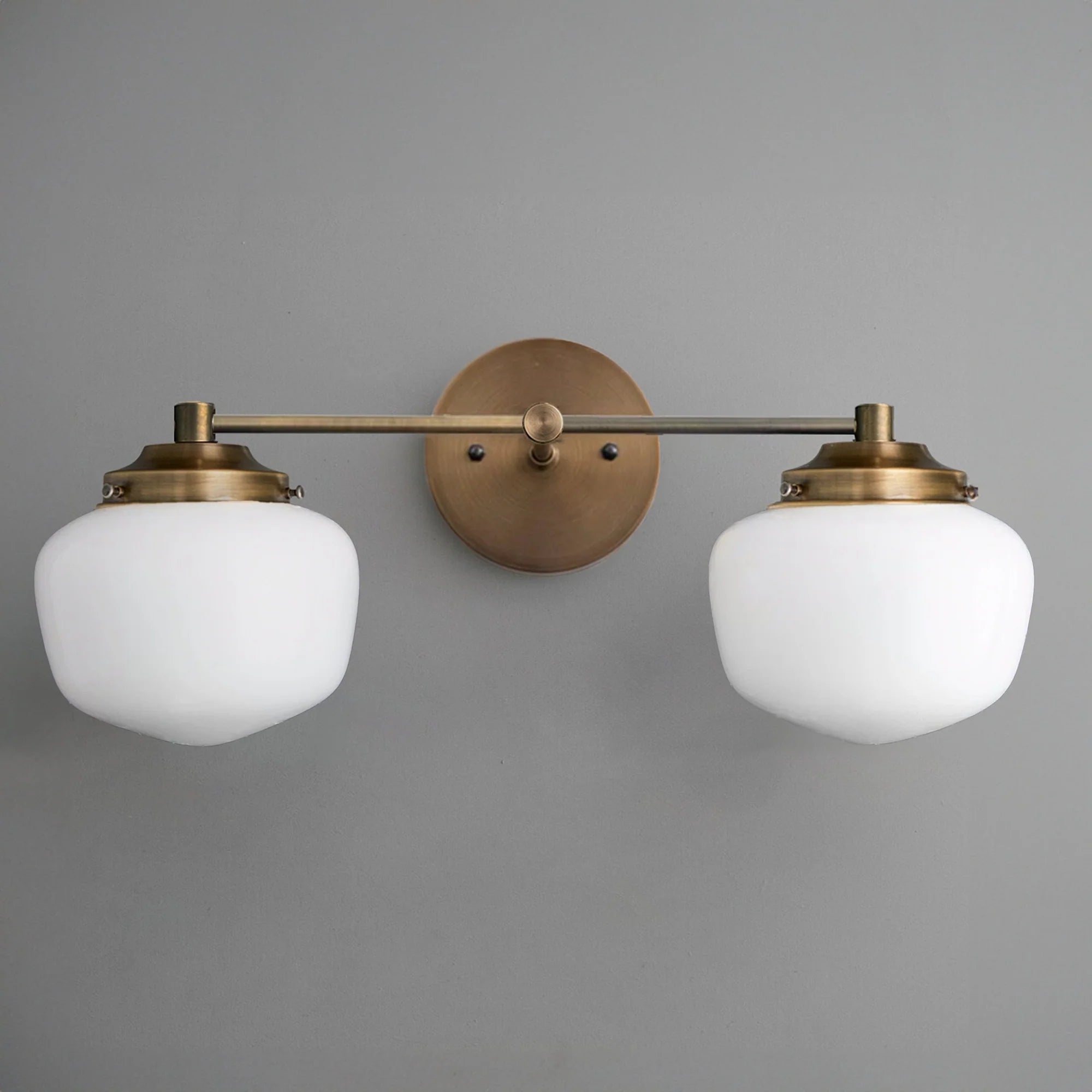 Mid-century modern two-bulb vanity light with round frosted glass globes and antique brass fixtures. - VANITY LIGHT MODEL NO. 5799