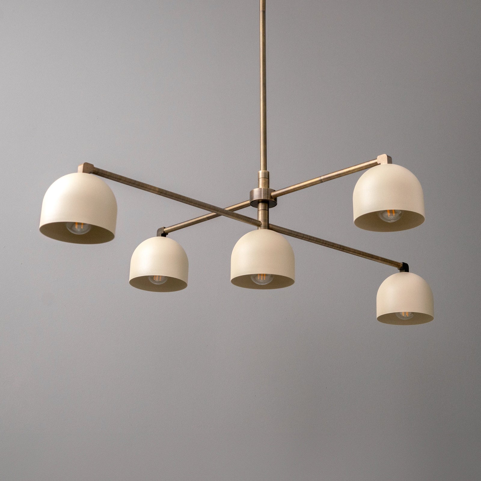 Antique brass chandelier with five cream dome shades on crossbar frame. - CHANDELIER MODEL NO. 8133