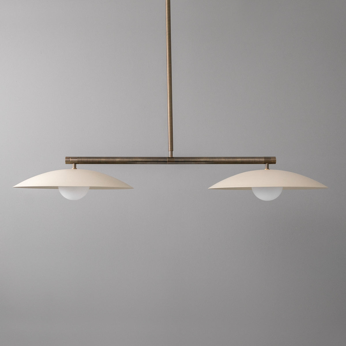 Linear chandelier with two white opaque globe lights and antique brass horizontal bar suspension. - CHANDELIER MODEL NO. 9708