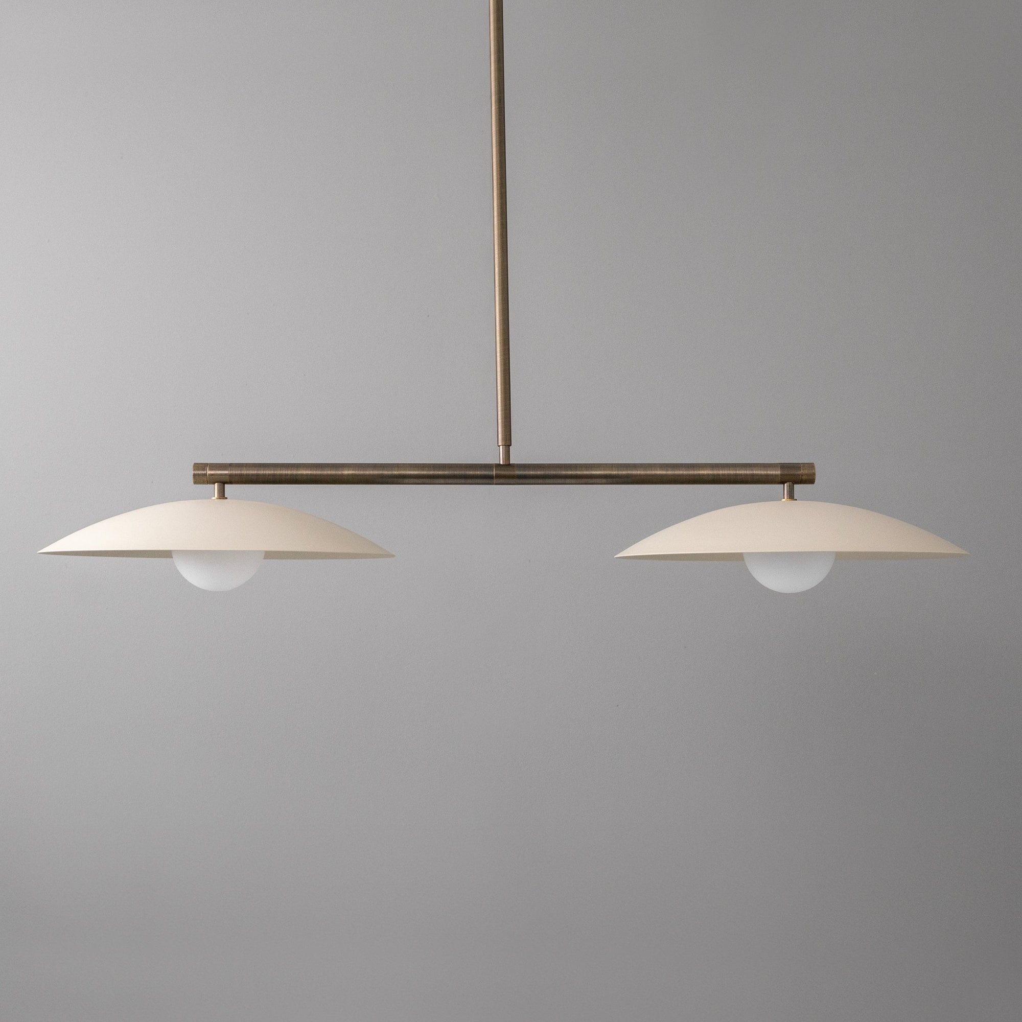 Linear chandelier with two white opaque globe lights and antique brass horizontal bar suspension. - CHANDELIER MODEL NO. 9708