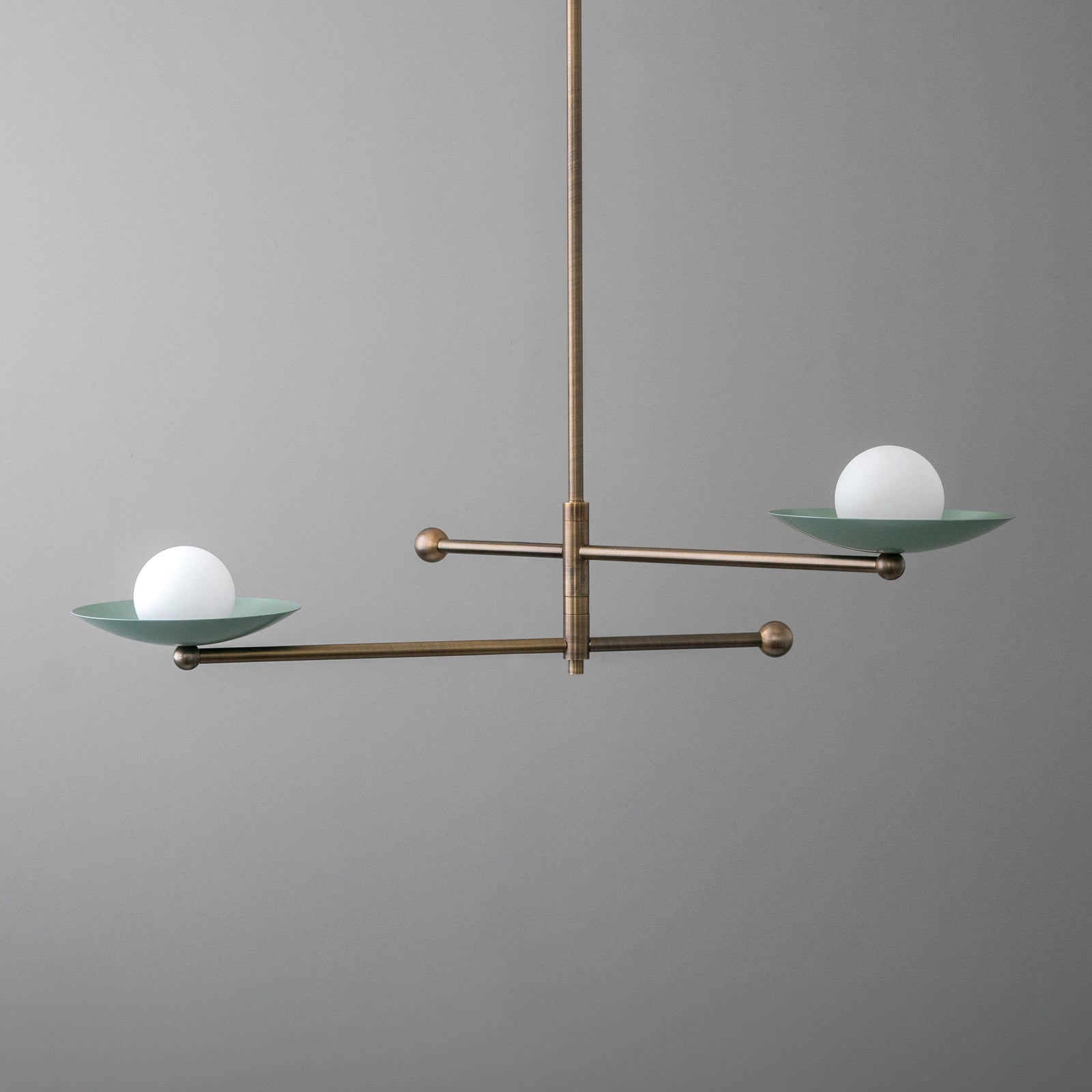 Antique brass chandelier with two horizontal arms and opal globe lights on green metal dishes. - CHANDELIER MODEL NO. 2933