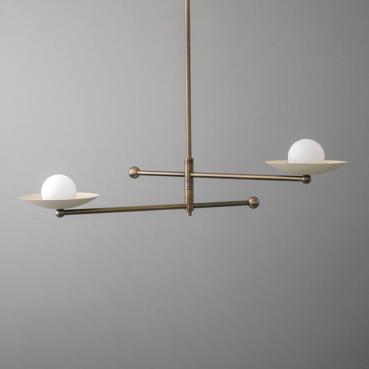 Mid-century modern chandelier with antique brass finish and two white globe lights on horizontal arms. - CHANDELIER MODEL NO. 2933