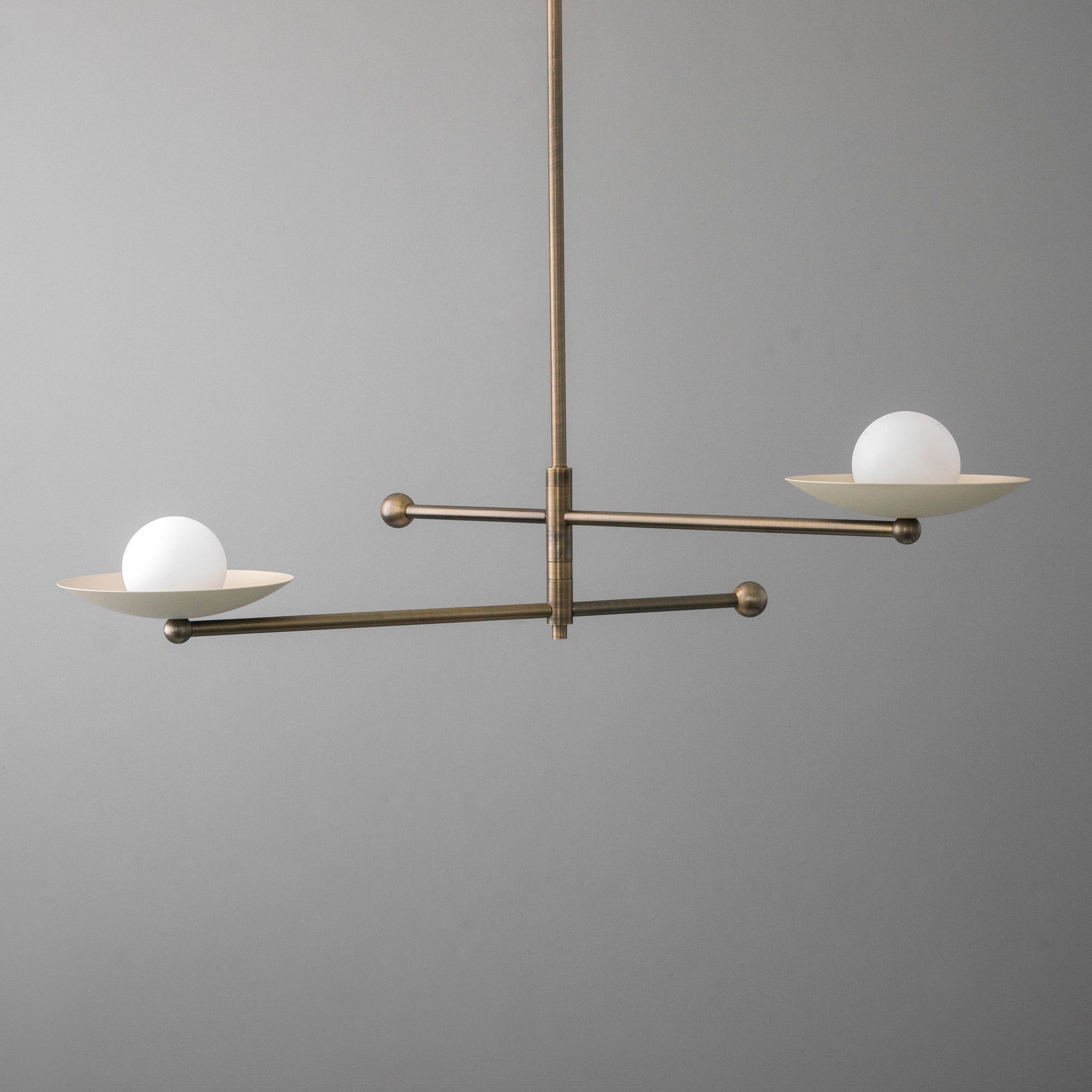 Mid-century modern chandelier with antique brass finish and two white globe lights on horizontal arms. - CHANDELIER MODEL NO. 2933