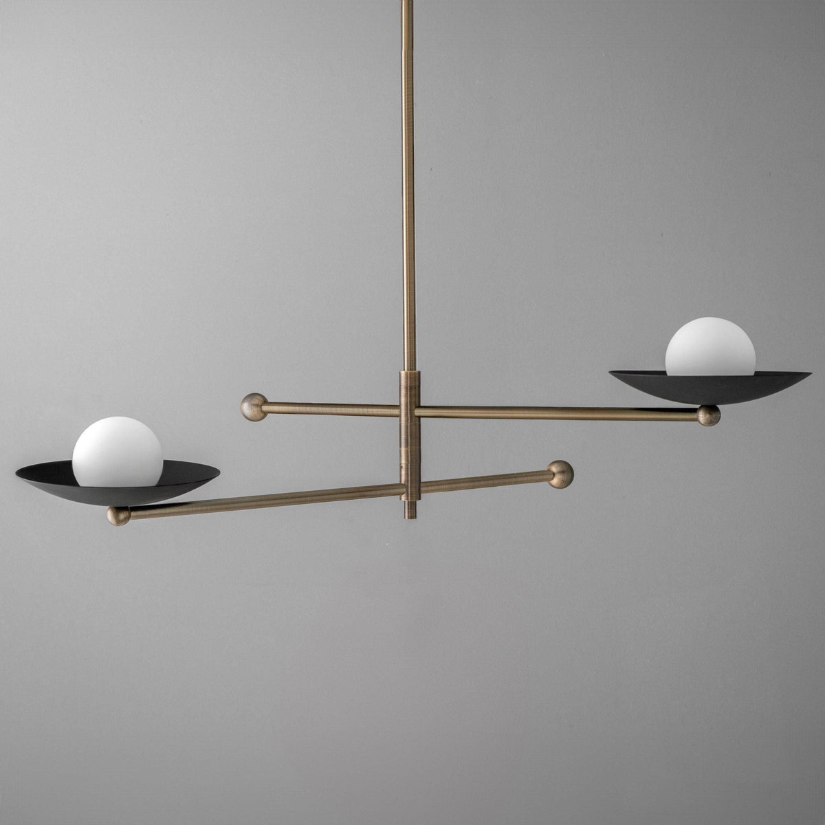Mid-century modern chandelier with antique brass arms and two white globe lights on black circular bases. - CHANDELIER MODEL NO. 2933