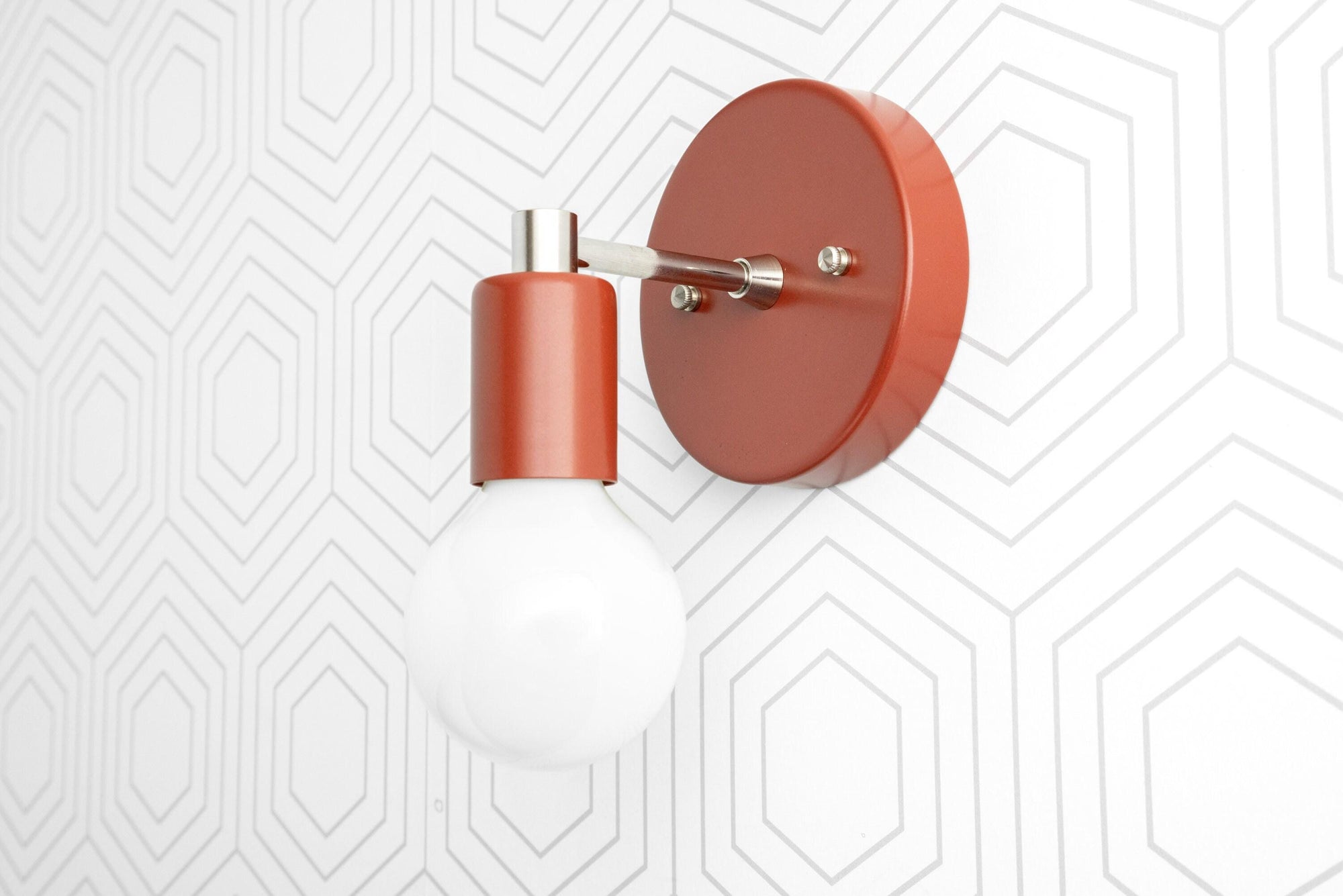Matte terracotta orange wall sconce with exposed round white bulb and brushed brass arm mount. - SCONCE MODEL NO. 9036
