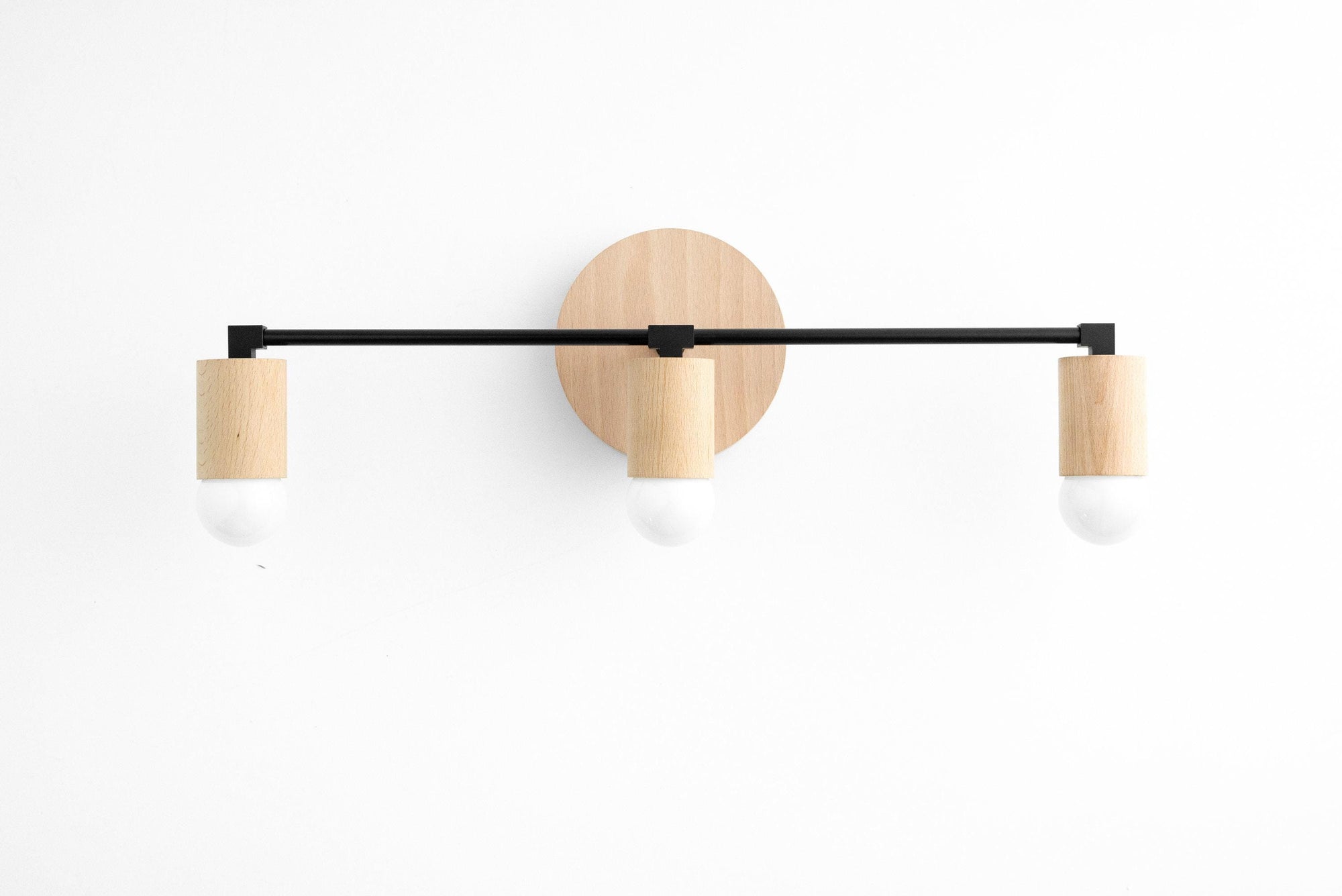 Three-bulb vanity light with black metal arms and beech wood accents on white background. - VANITY LIGHT MODEL NO. 4446