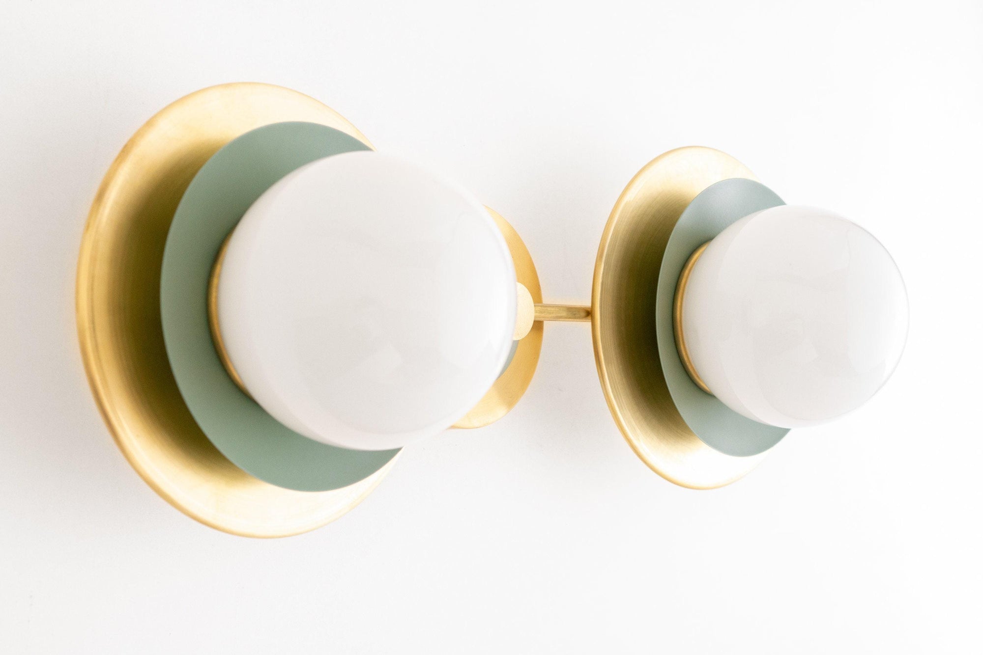 Mid-century modern 2-bulb vanity light with raw brass and green circular backplates and frosted globe bulbs. - VANITY LIGHT MODEL NO. 9361