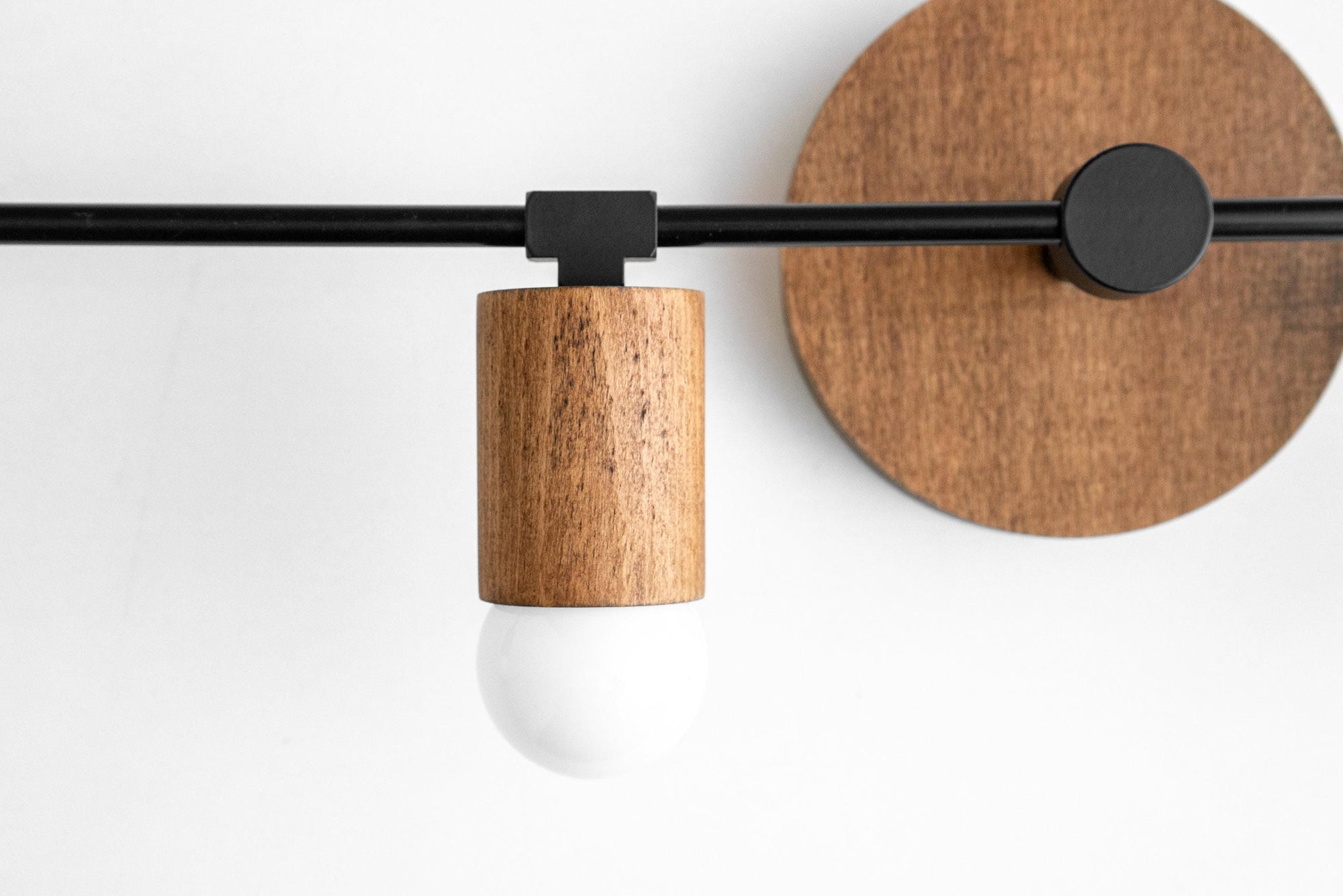 Minimalist vanity light with natural oak wood socket and black metal arm on round wood mount. - VANITY LIGHT MODEL NO. 2017
