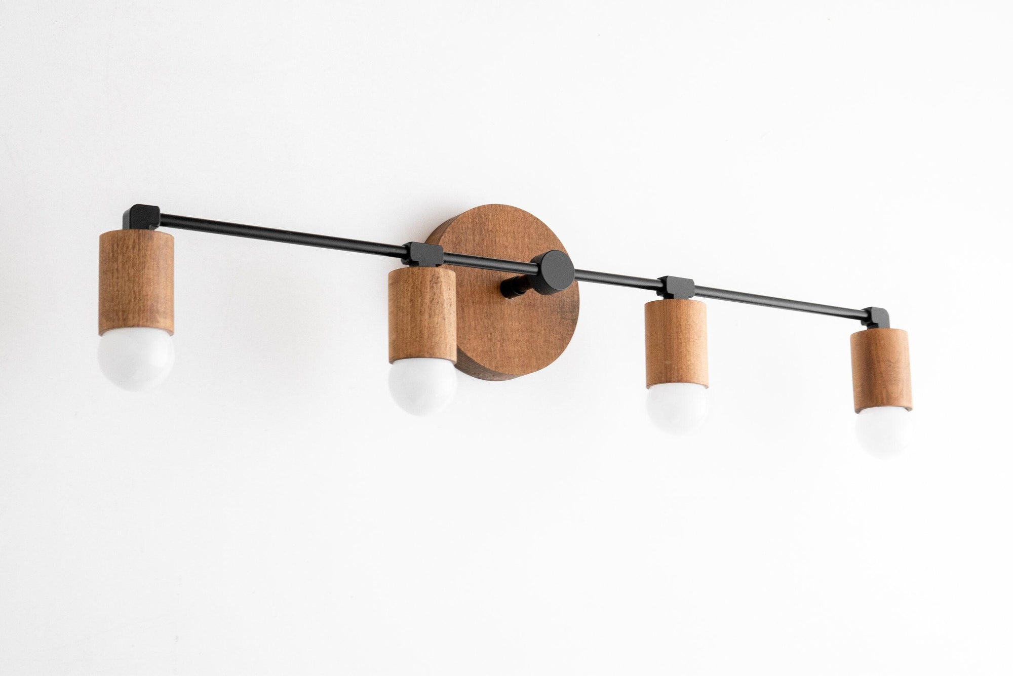 Four-bulb vanity light with black metal bar and natural wood cylindrical mounts on round wooden base. - VANITY LIGHT MODEL NO. 2017