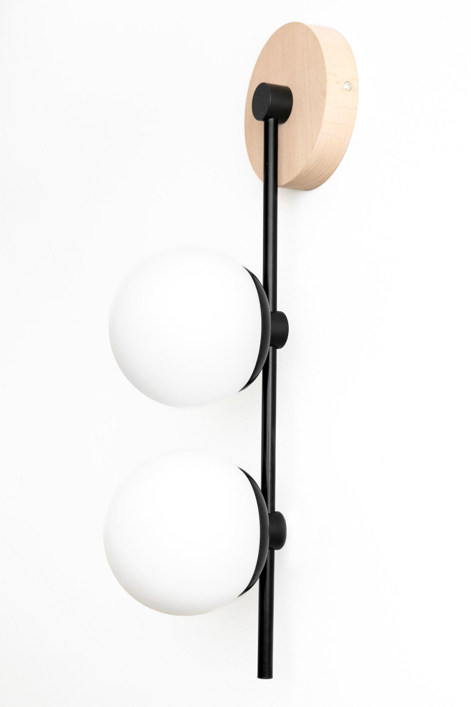 Black wall sconce with vertical matte black rod and two white frosted glass globes. - SCONCE MODEL NO. 0344