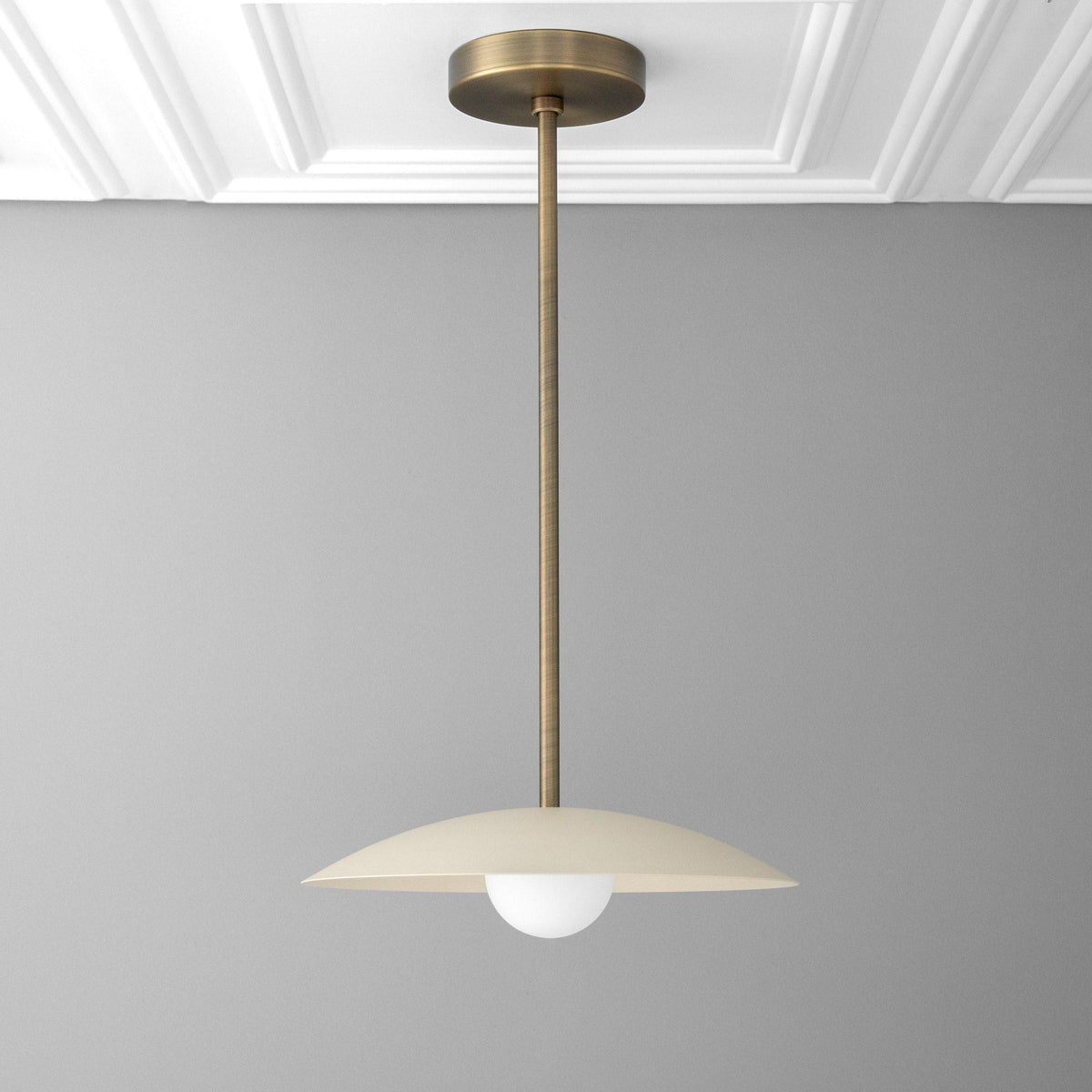 Mid-century modern antique brass pendant with cream flat dome shade and exposed globe bulb. - PENDANT MODEL NO. 4085